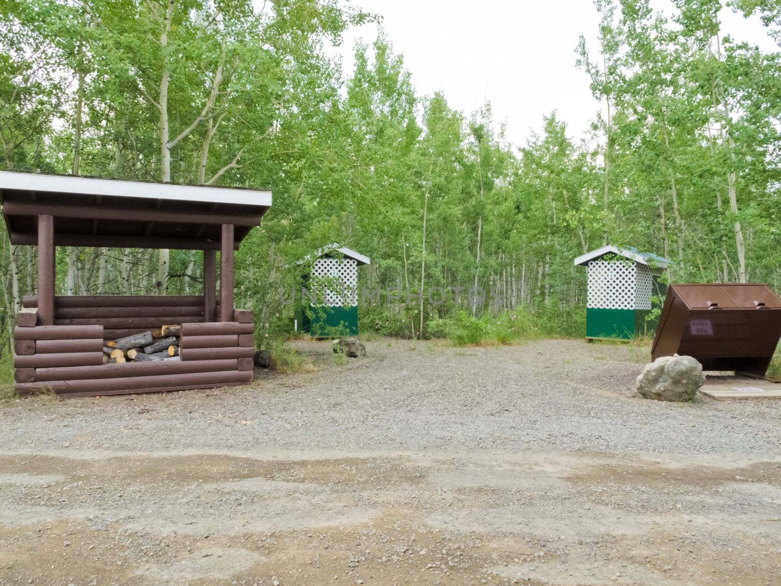 Simple campground facilities, firewood shed, bear-proof garbage bin and pit toilet outhouses on public Yukon Territory Government campground, Yukon, Canada
