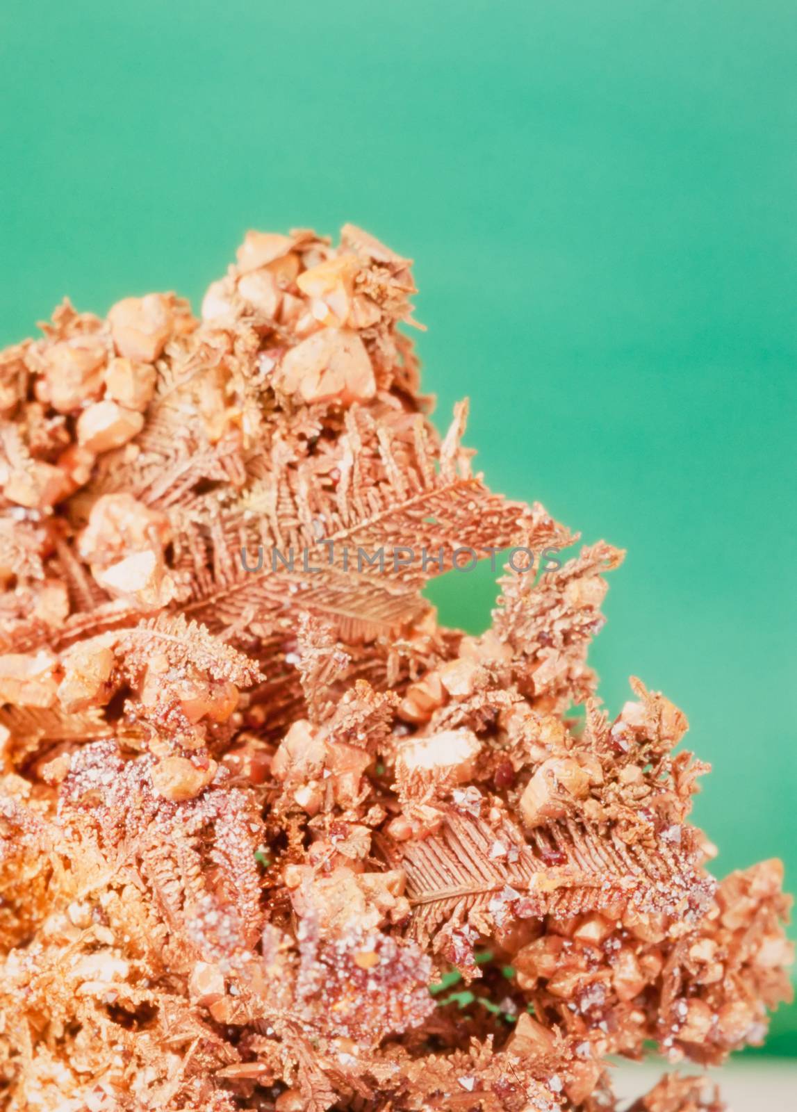 Native copper crystalline metal mineral rock against neutral green background