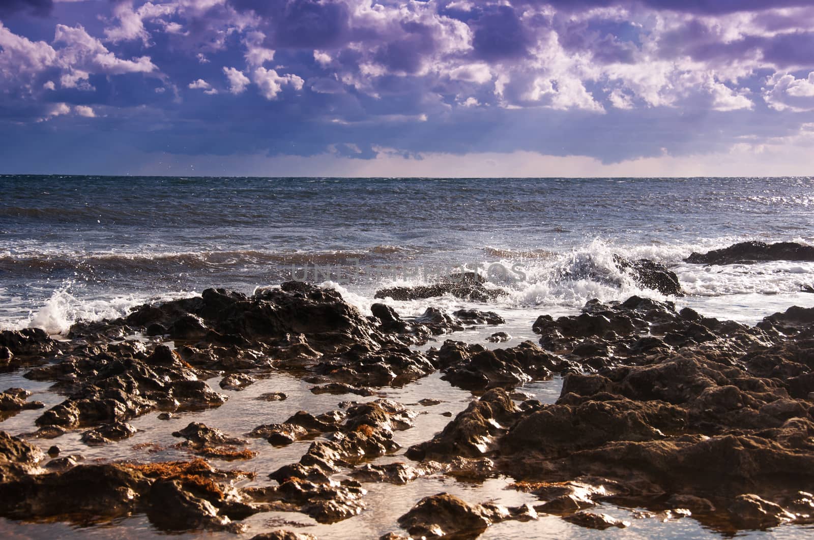 Sea during the ebb. rocky seashore. Clouds and rain away.