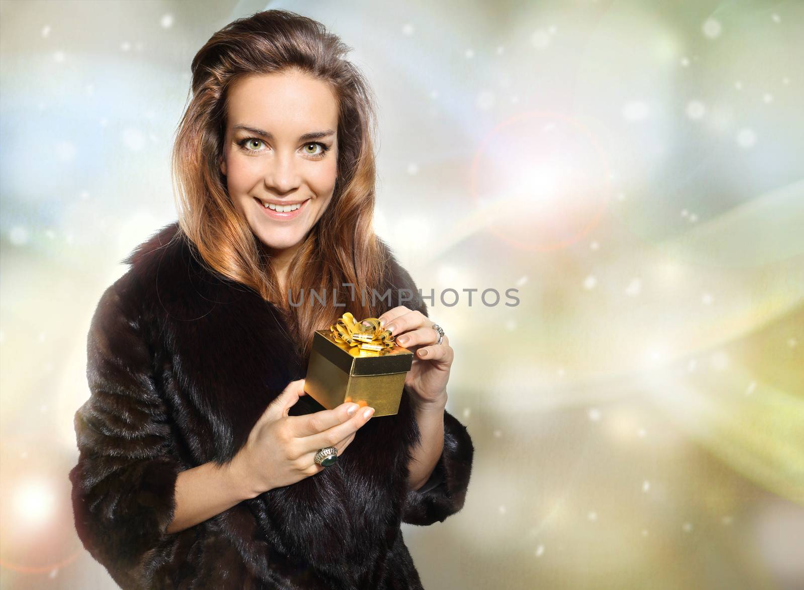 Exclusive lady in a fur coat holding a gold gift