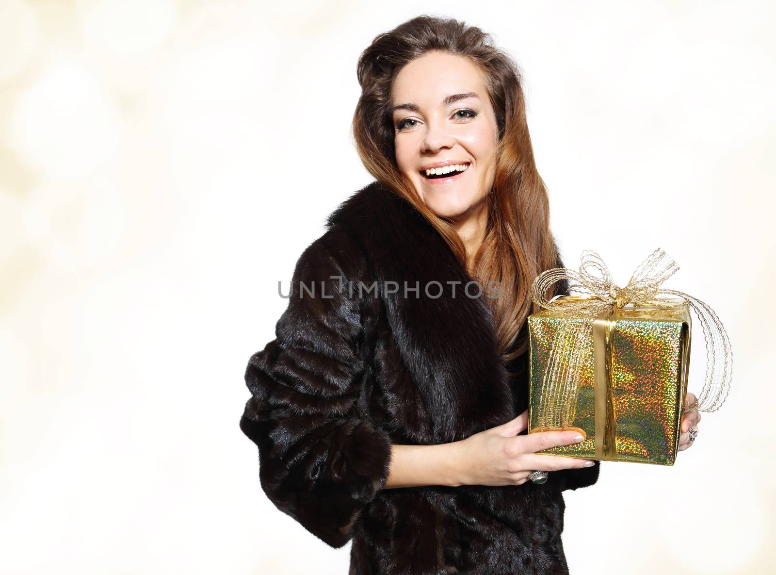 Elegant lady in a fur coat with a gold gift