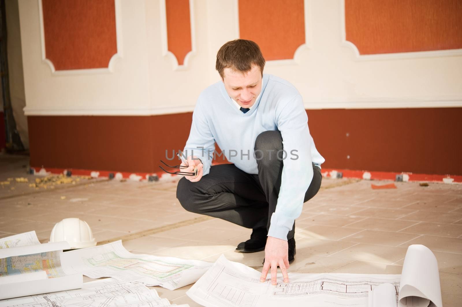 Architect looking blueprint on the floor. Reconstruction interior.