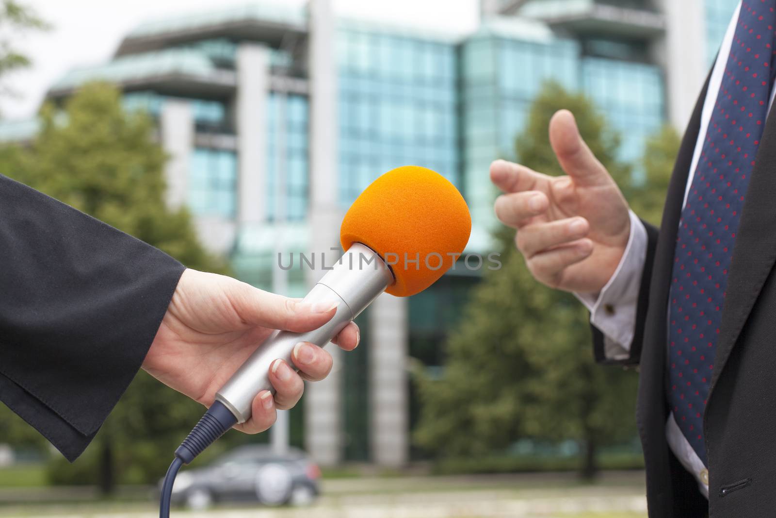 Journalist hand holding a microphone conducting an TV od radio interview