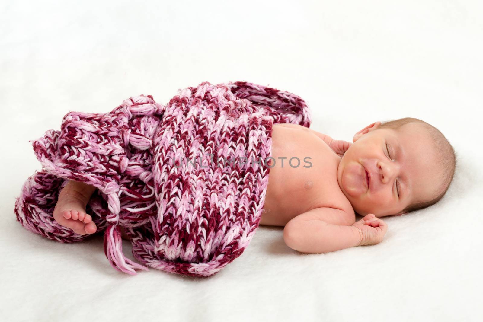 sleeping newborn baby in shawl on white blanket - the first week of the new life