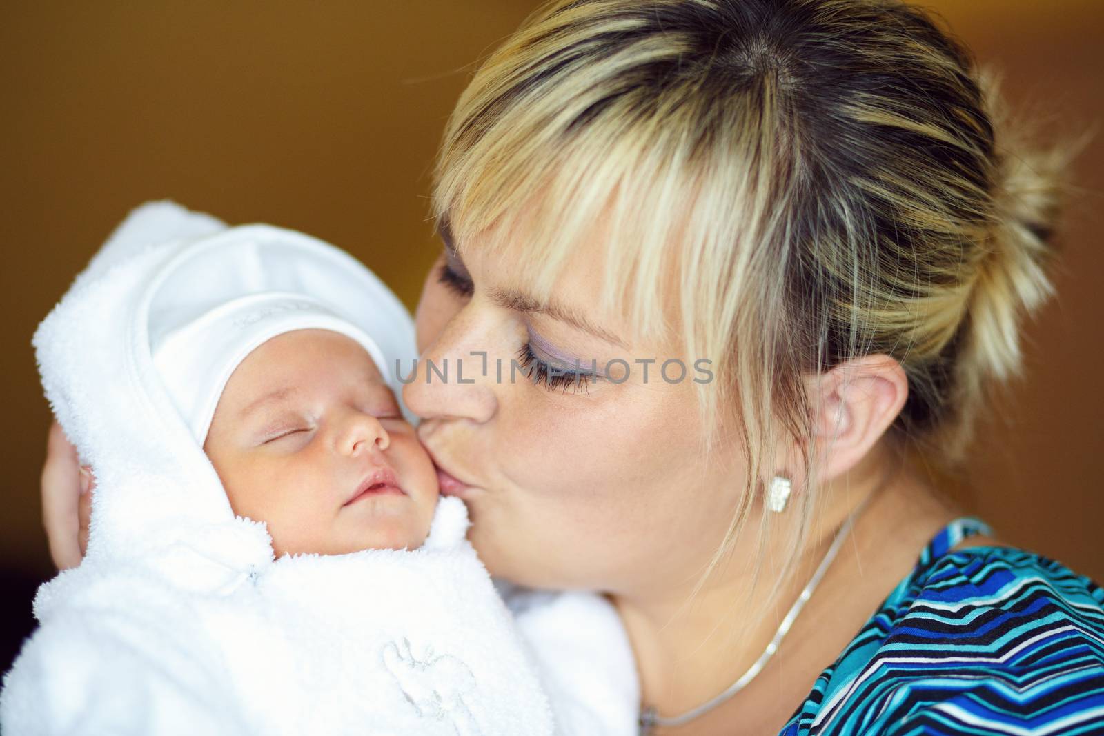 mother with her cute little baby girl, first month of the new life, focus to mother, kissing infant