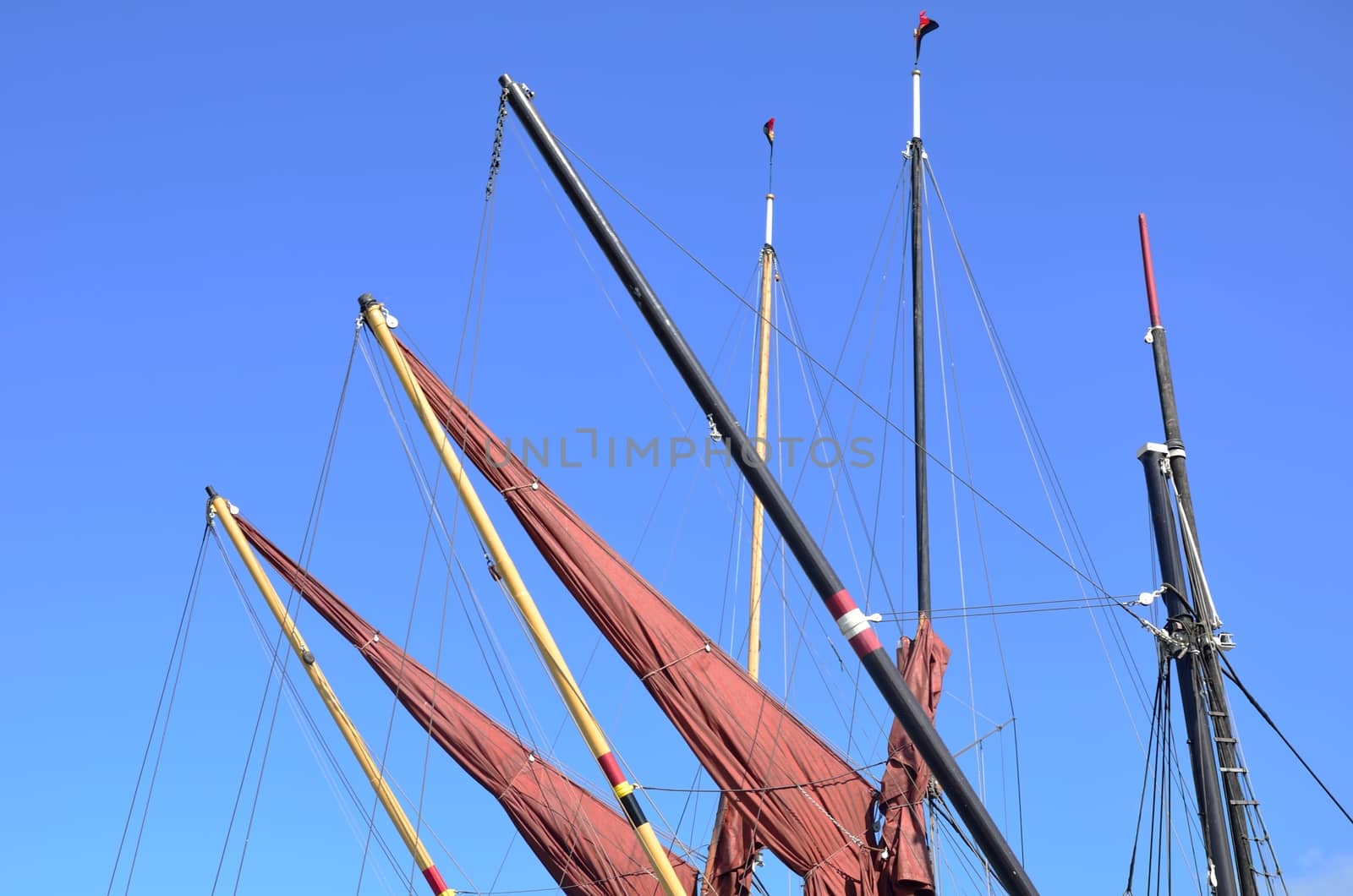 Red sails furled on jibs