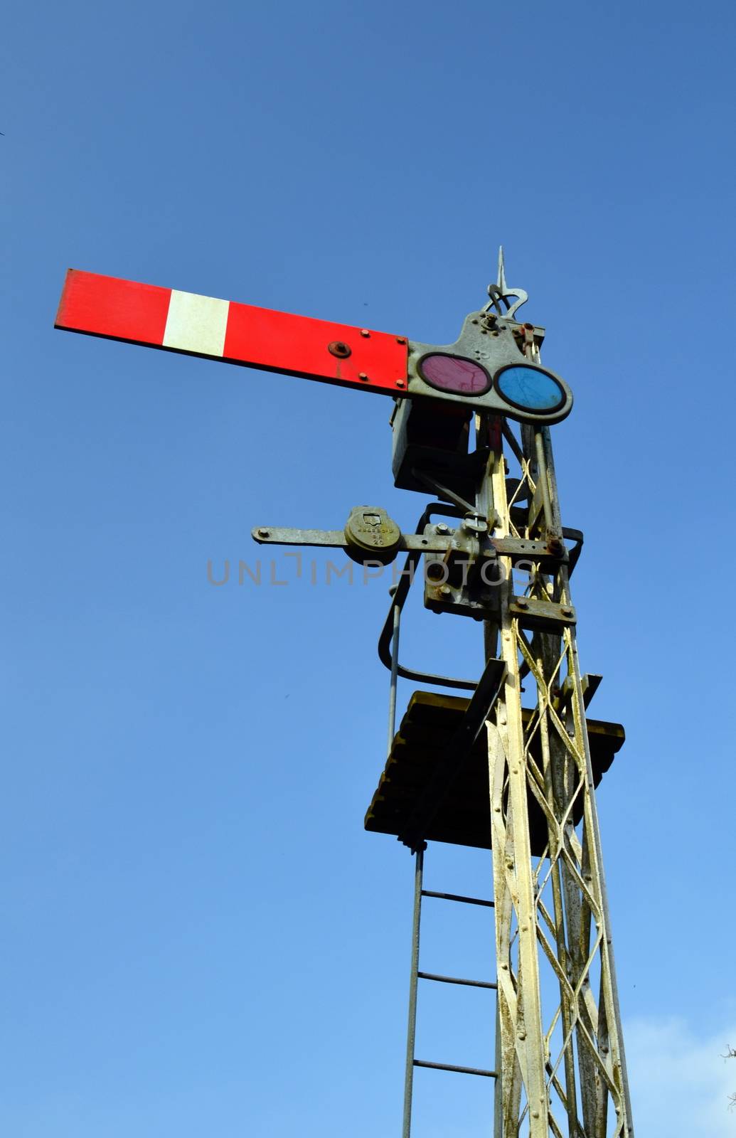 Rural British railway signal in stop position.
