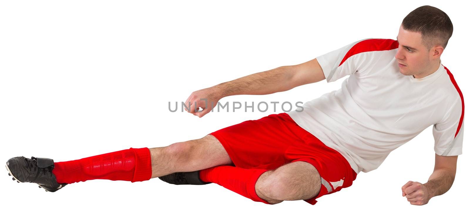 Fit football player playing and kicking on white background