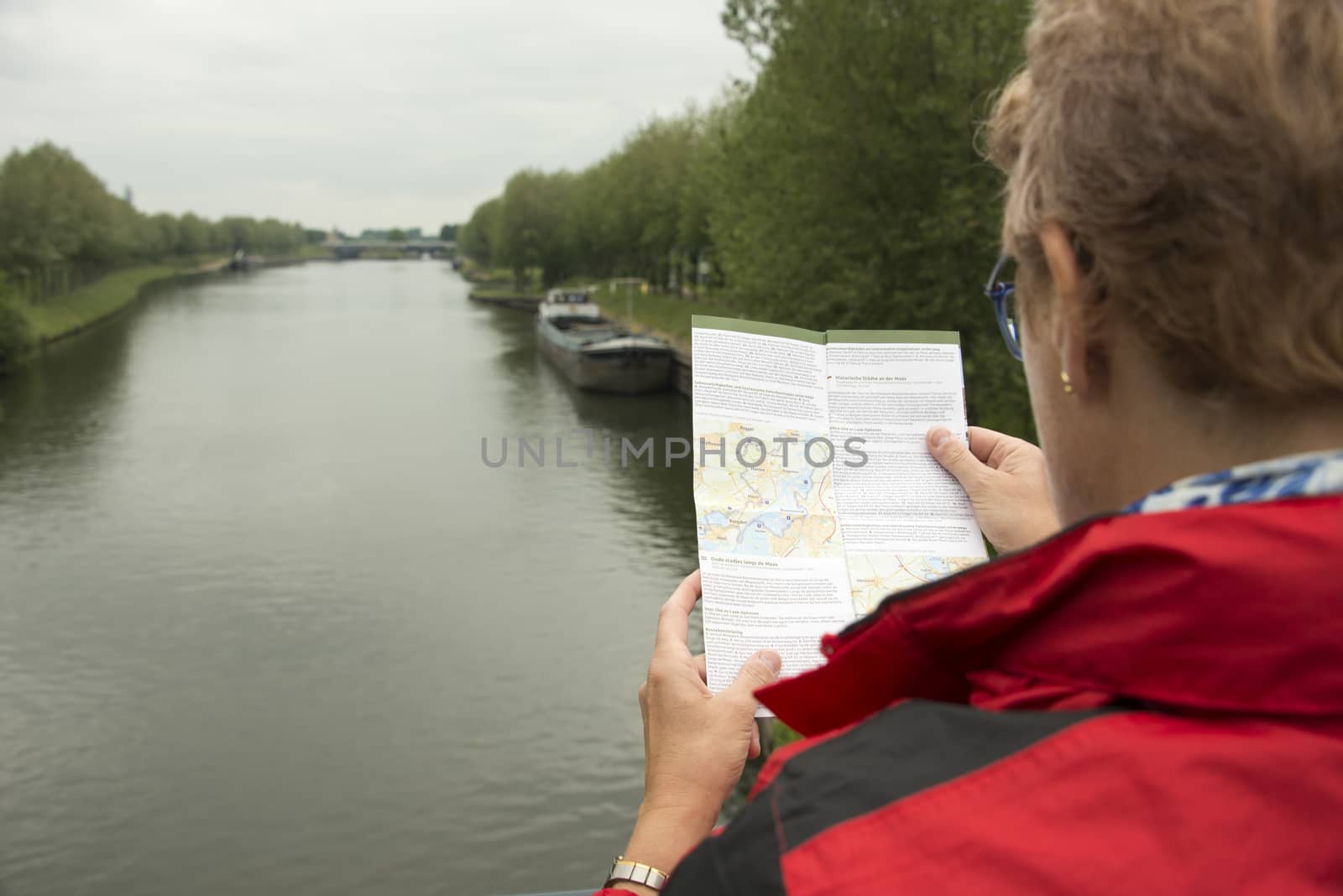 woman in red coat reading the information about a route