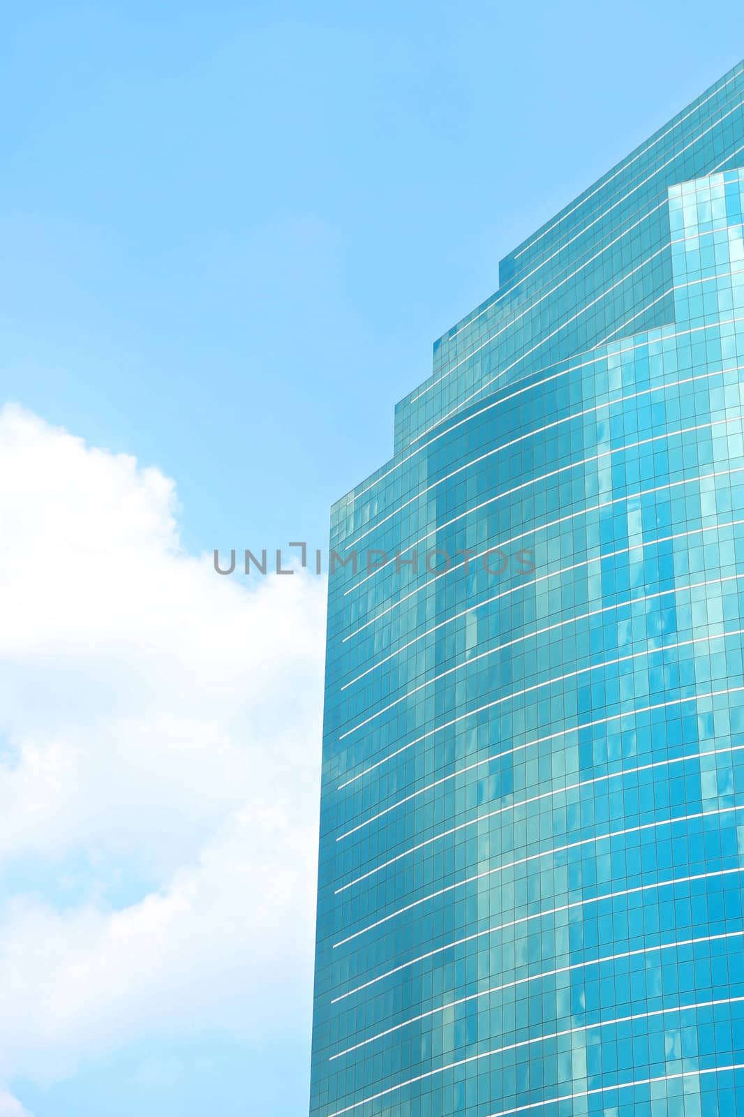 Skyscraper building with blue glass reflection blue sky with cloud.