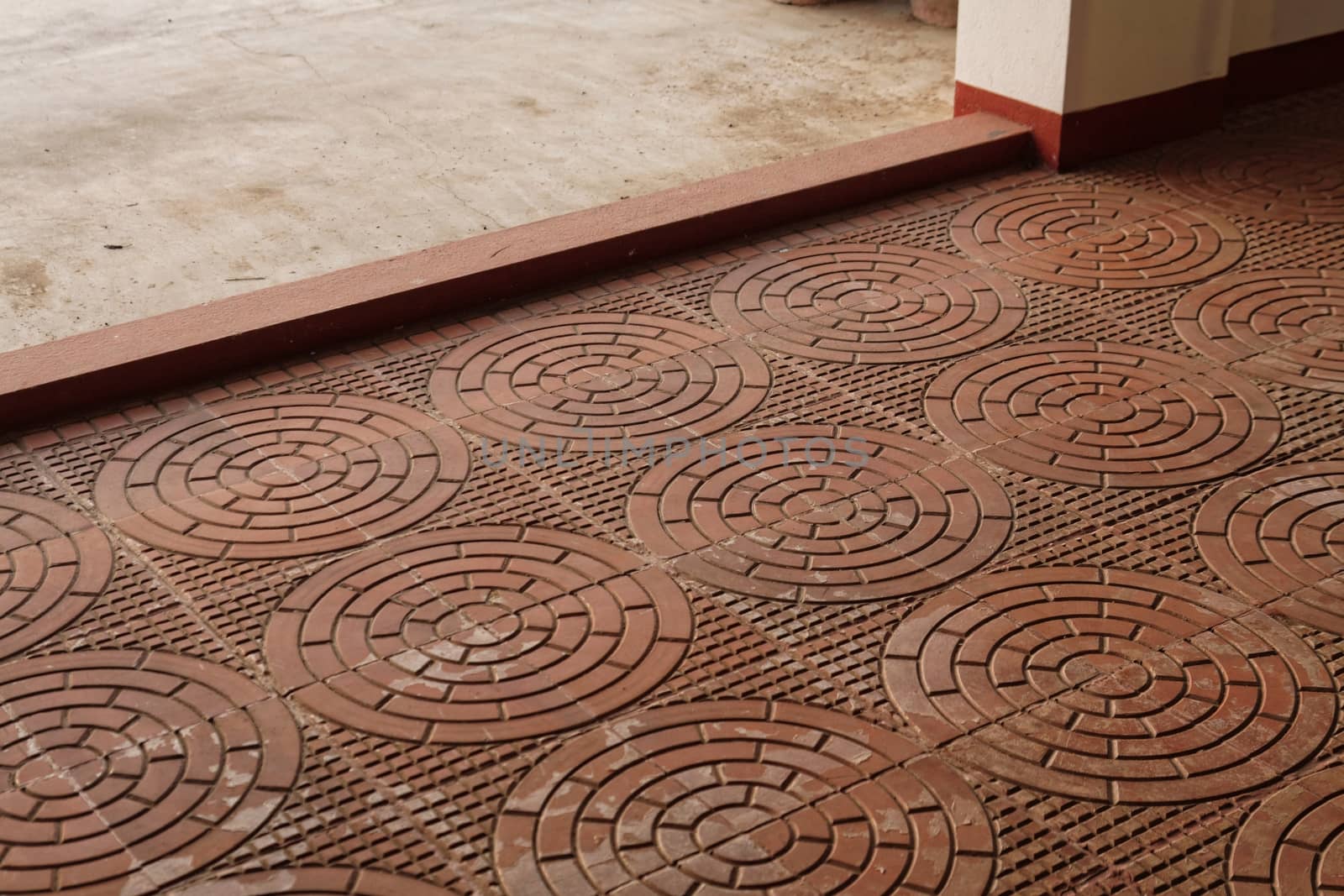 Intricately designed terracota tiles in a classic design are used on a verandah 