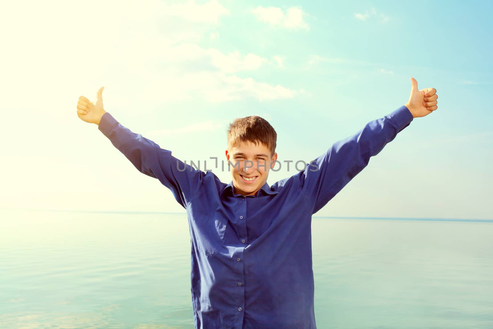 Toned photo of Happy Teenager with Hands Up on the Sea background
