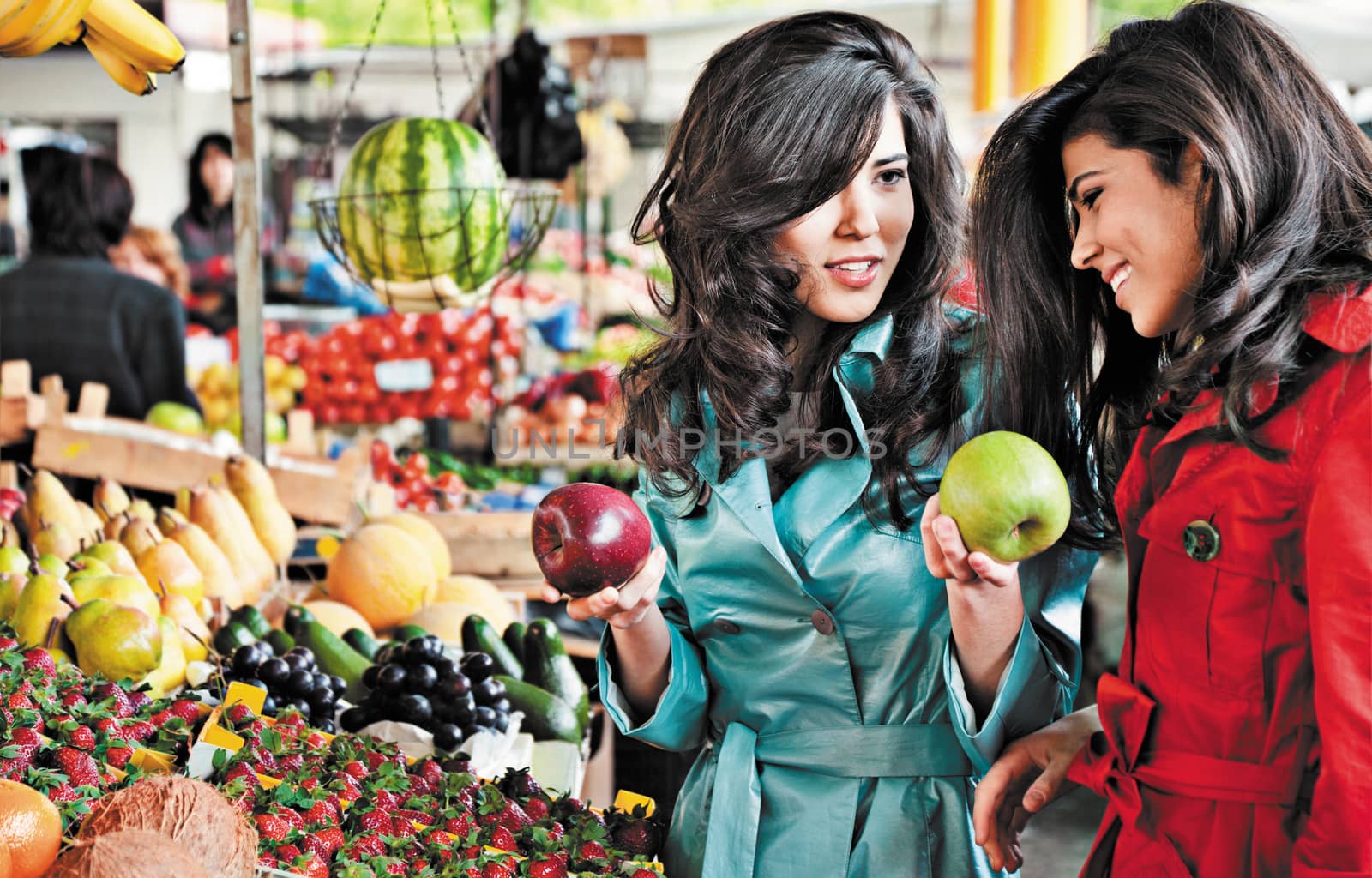 sisters shopping fruits at an outdoors farmers market