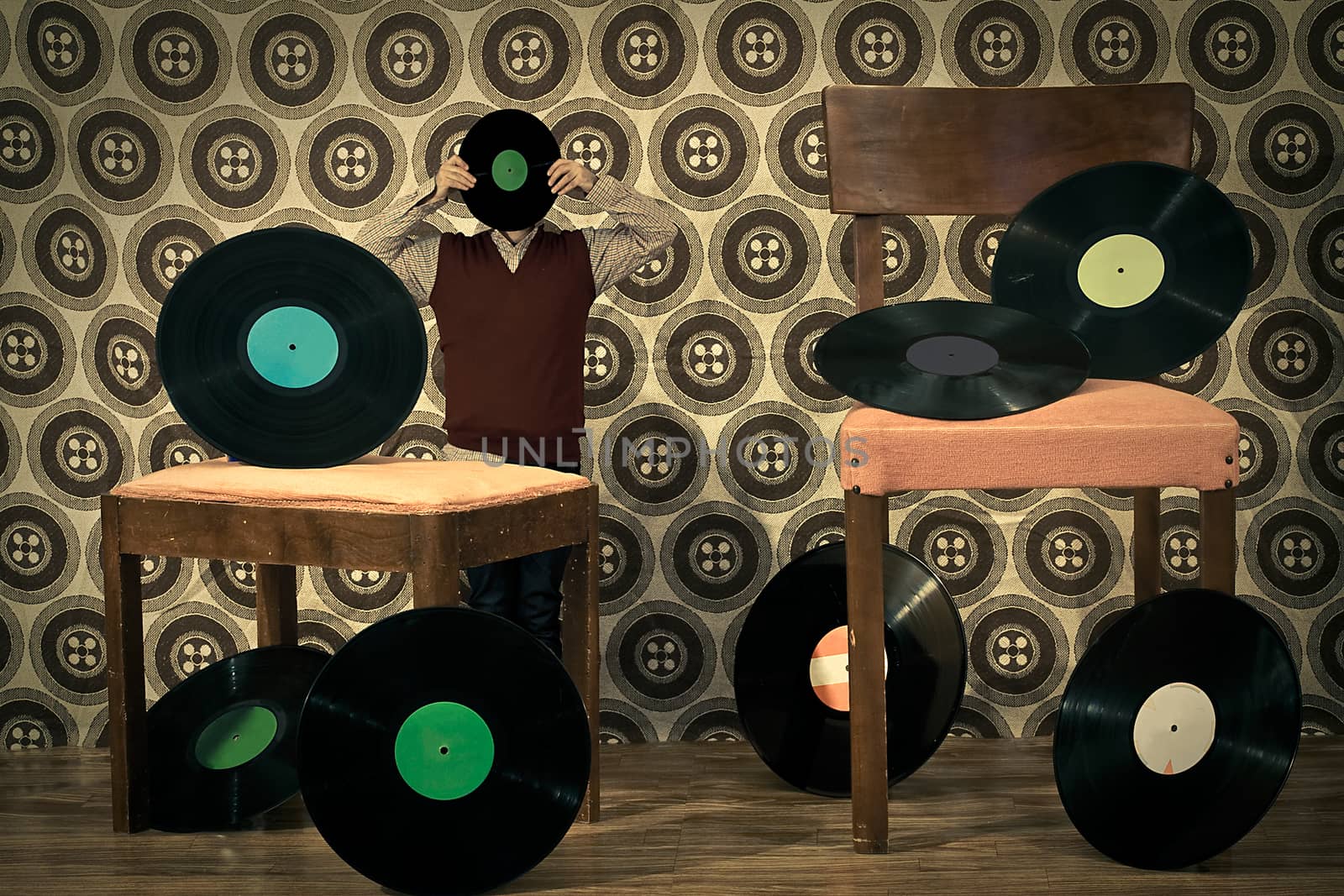 retro room full with 33rpm discs on chair, a little man with a lp face is behind a footrest