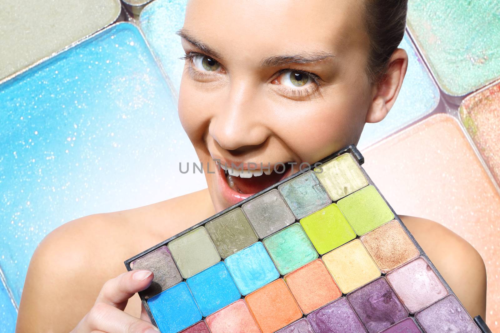 Beautiful woman with multicolored eyeshadow palette