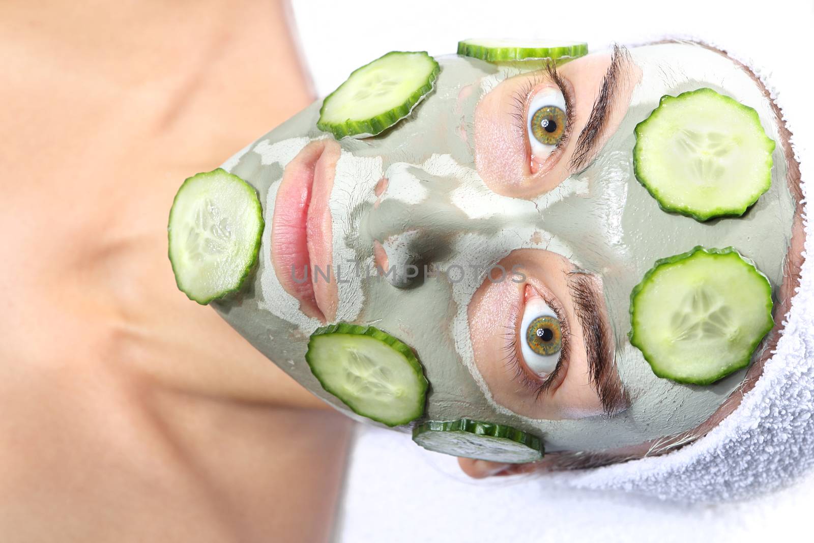 woman relaxes in the mask with green clay and cucumber