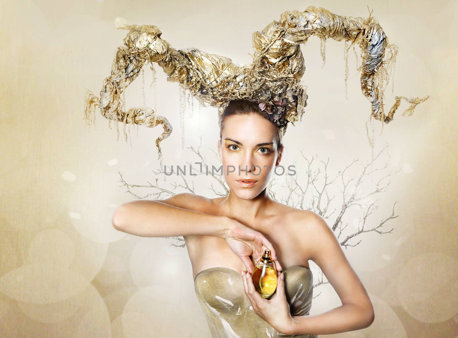 woman with golden horns is holding a perfume bottle