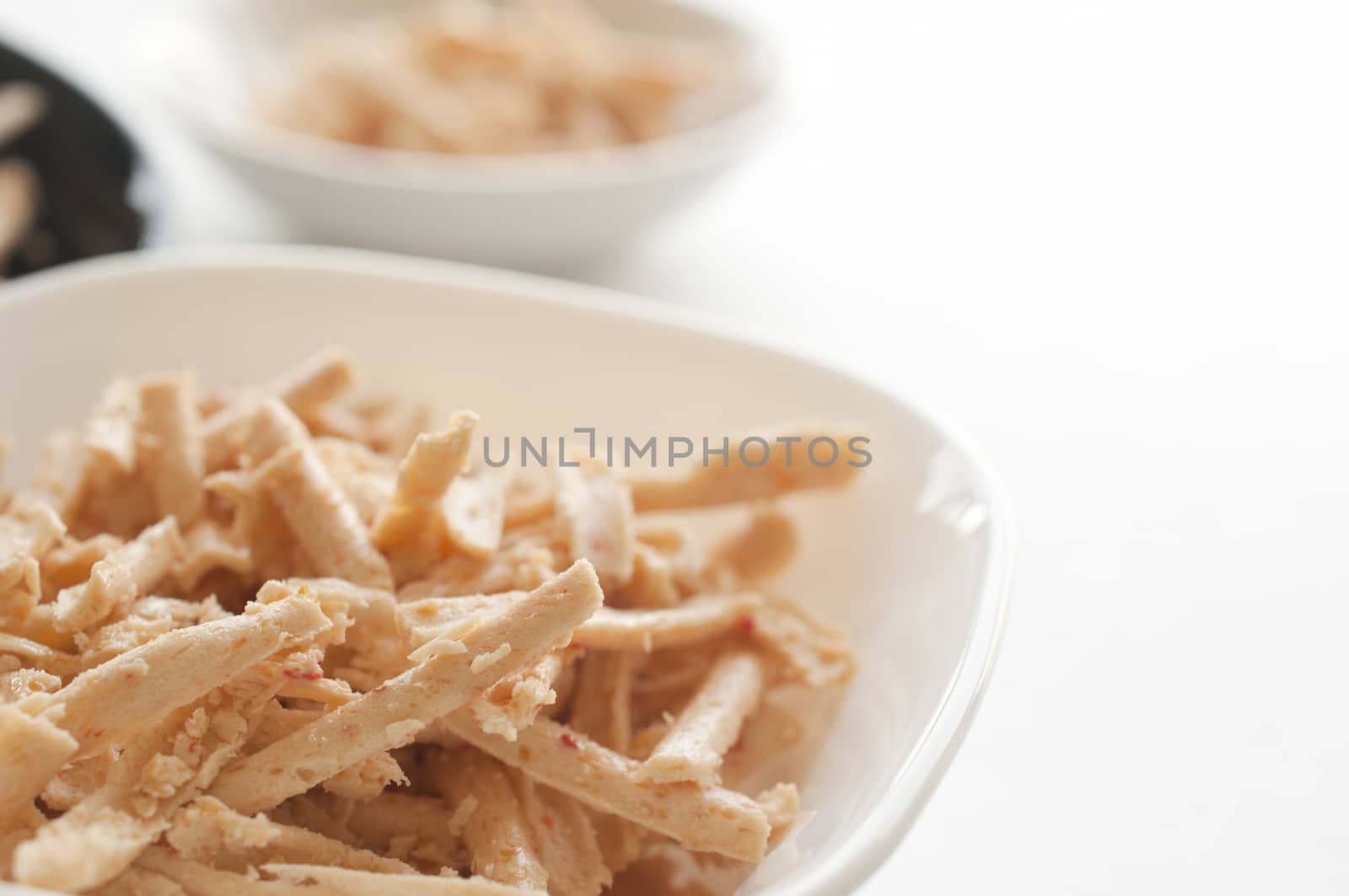 Bowl of grated cheese on white background