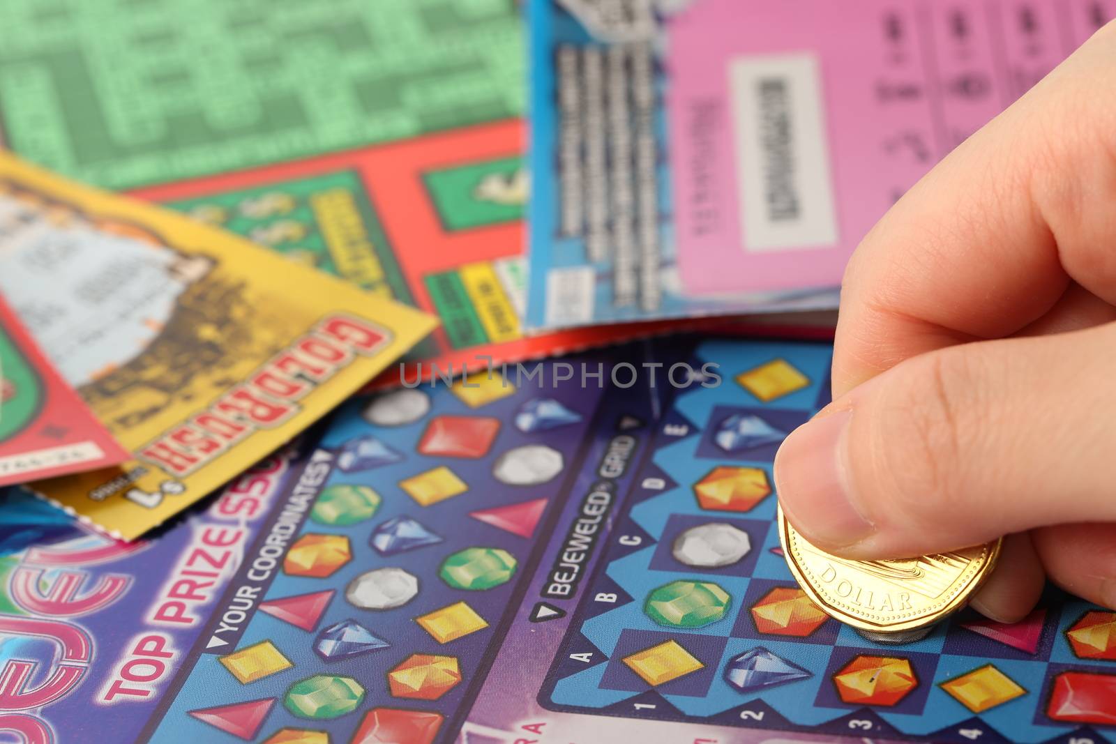 Coquitlam BC Canada - May 25, 2014 : Scratching lottery tickets. The British Columbia Lottery Corporation has provided government sanctioned lottery games in British Columbia since 1985. 