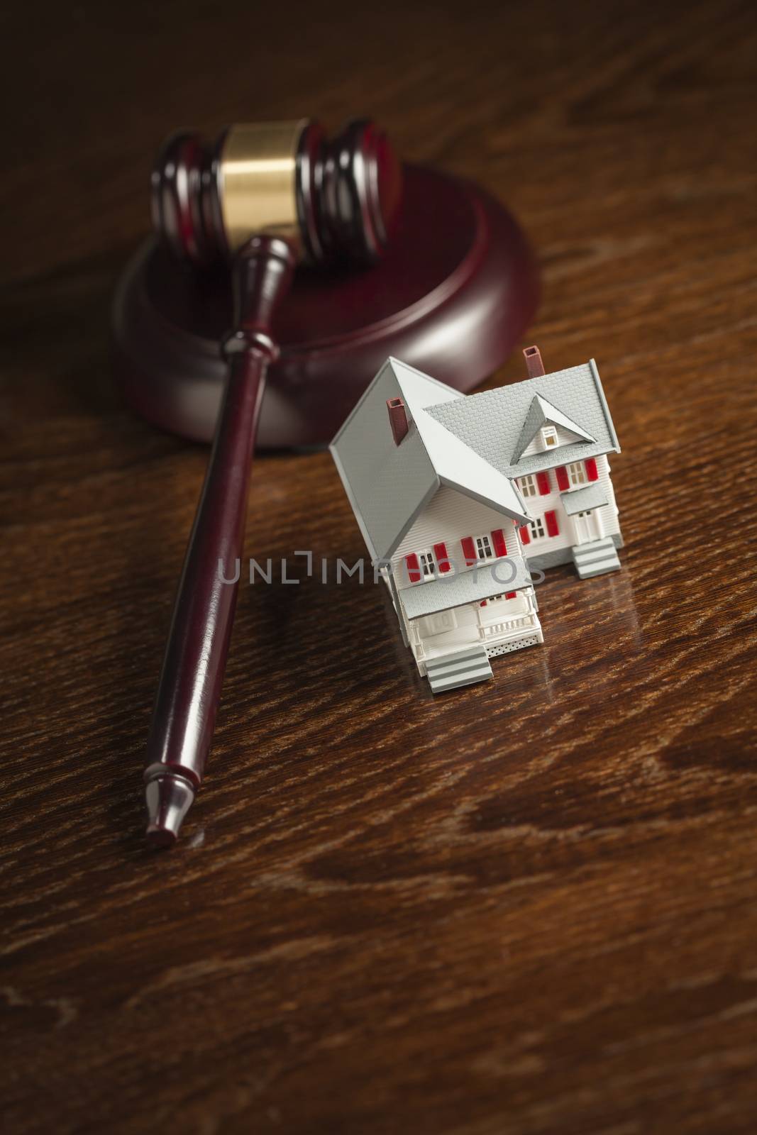 Gavel and Small Model House on Wooden Table.