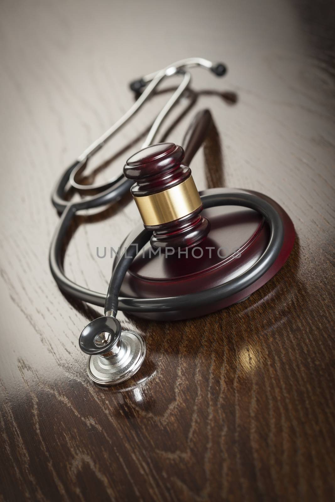 Gavel and Stethoscope on Reflective Wooden Table.