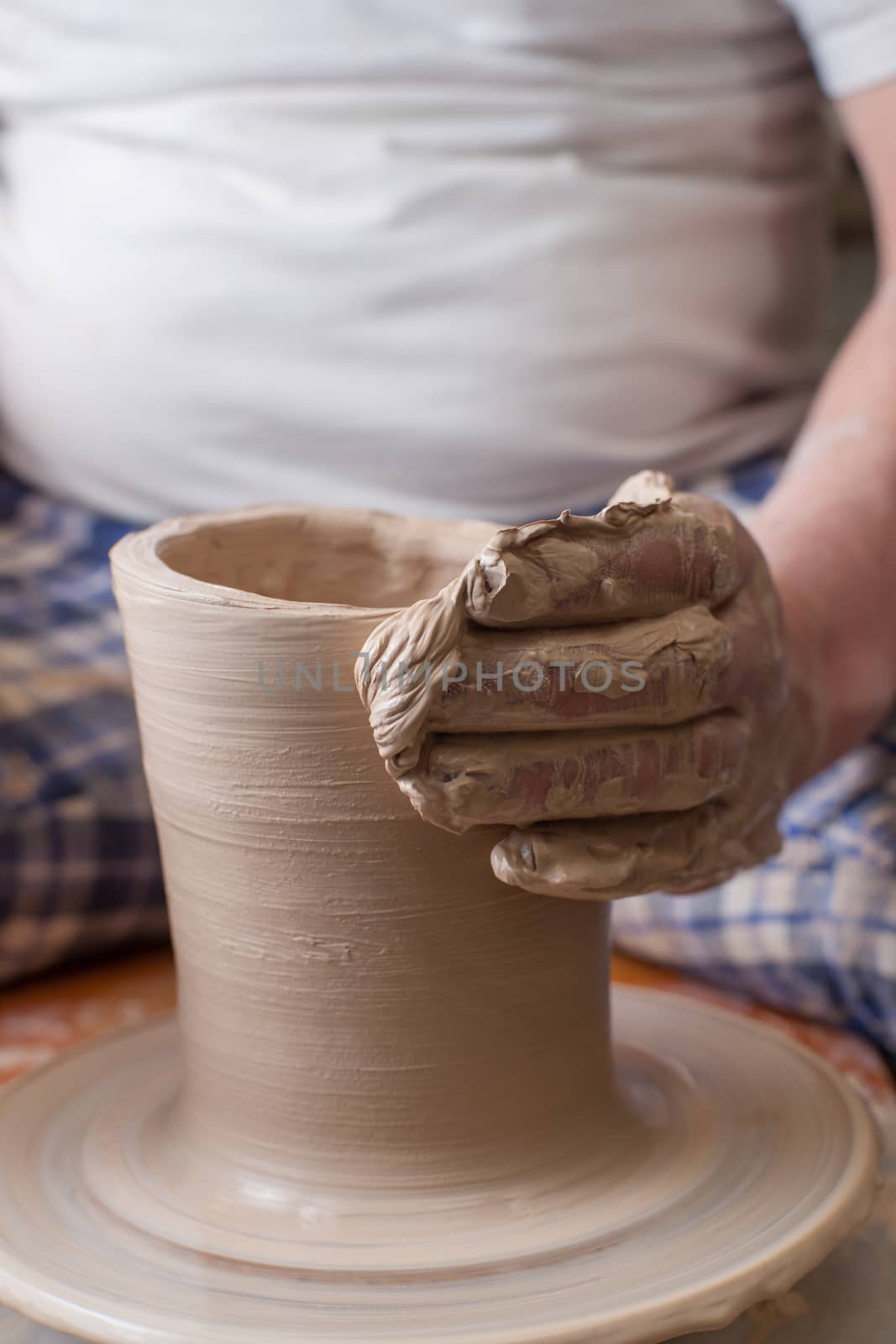 Hands of a potter, creating an earthen jar on the circle