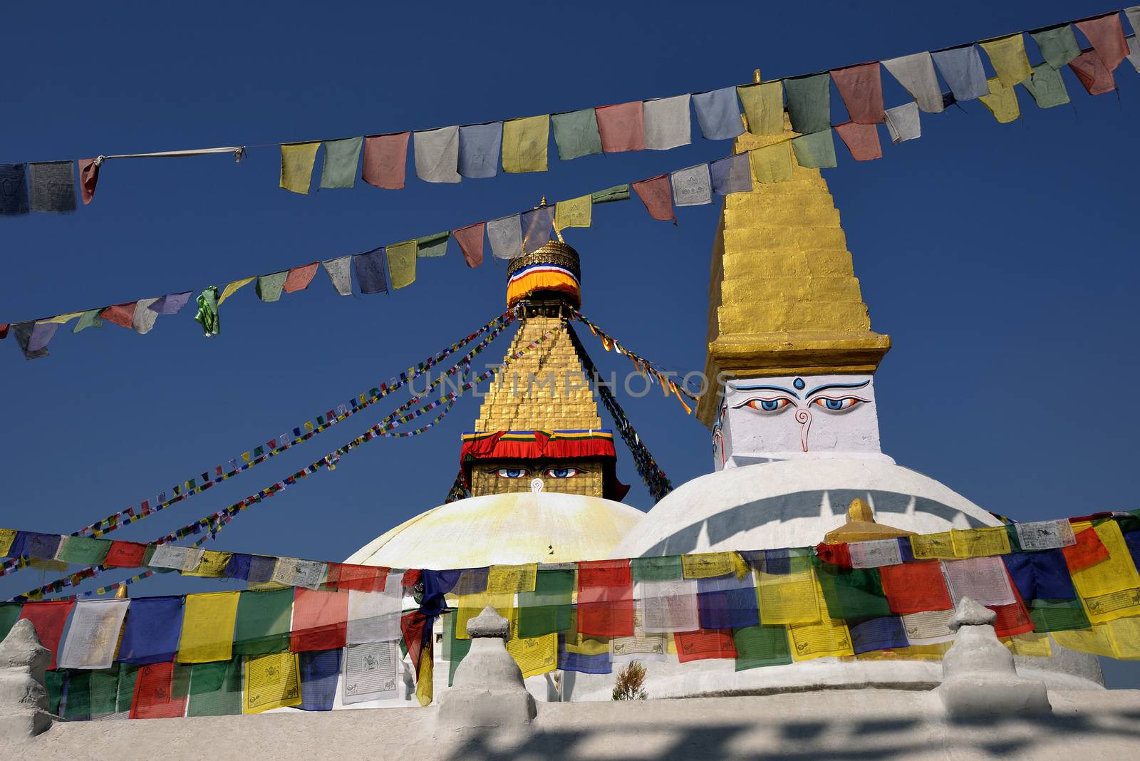 Boudhanath Stupa. Golden spire and all seeing Buddha eyes on top by think4photop