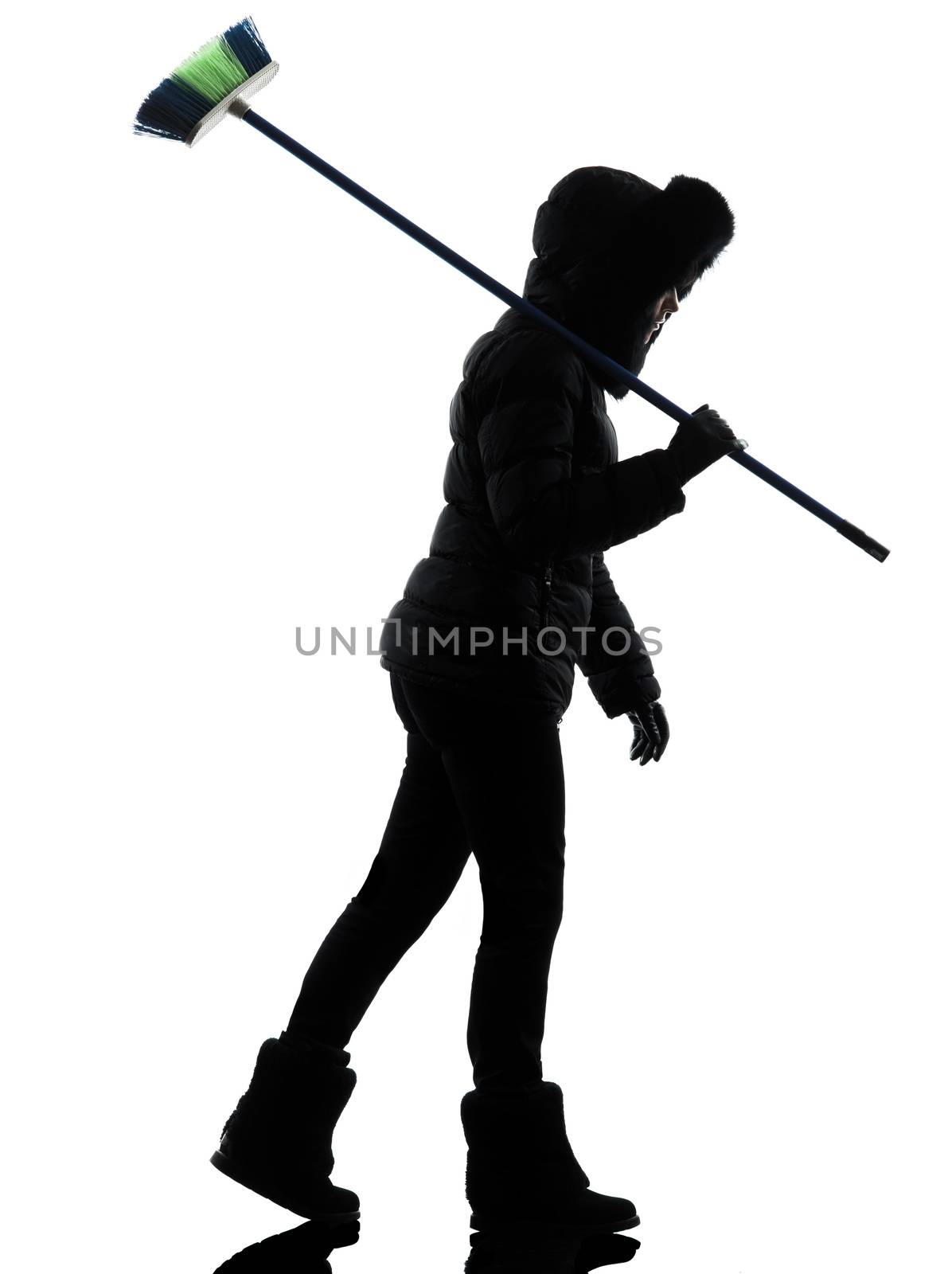 one woman in winter coat walking brooming silhouette on white background