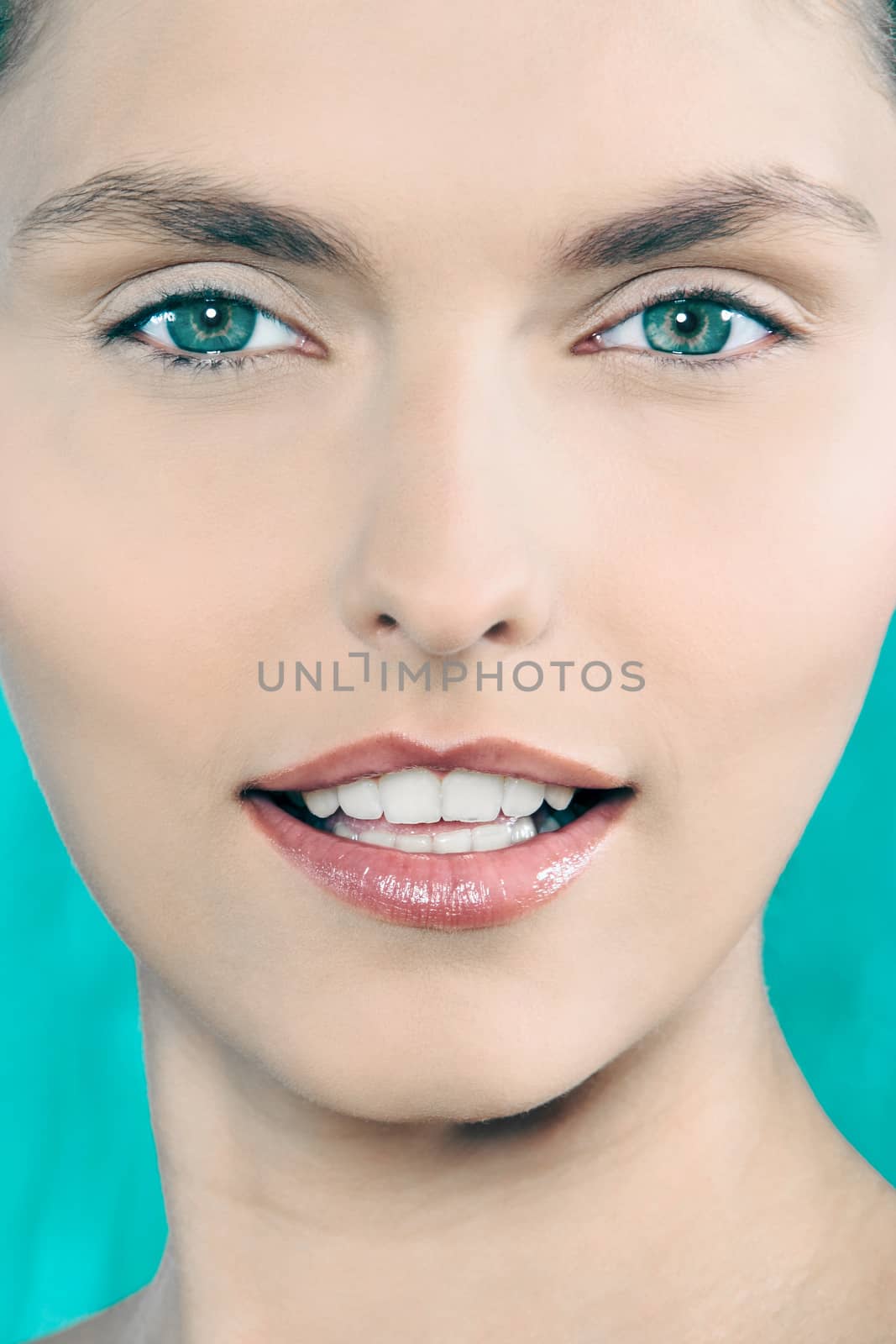 studio shot beauty portrait of a beautiful green eyes caucasian young woman on a blue background
