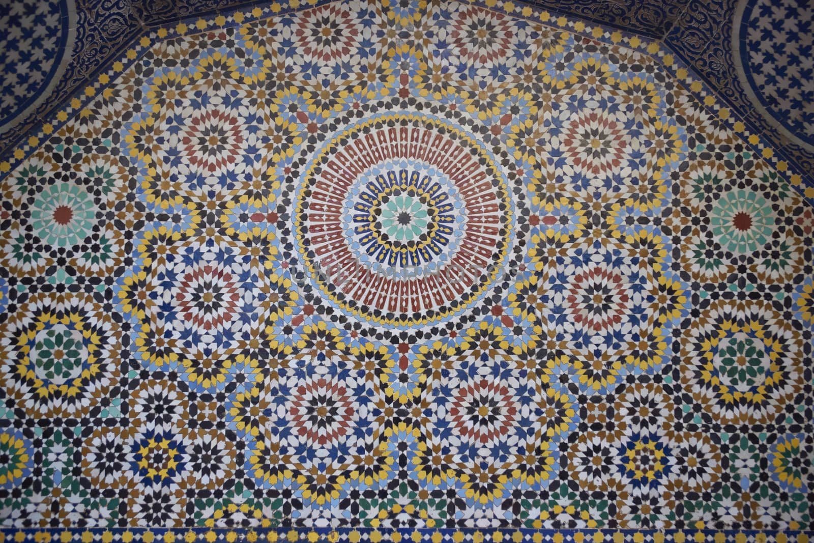 Ornate mosaic adorning the back of a traditional islamic water fountain in the ancient city of Fes in Morocco.