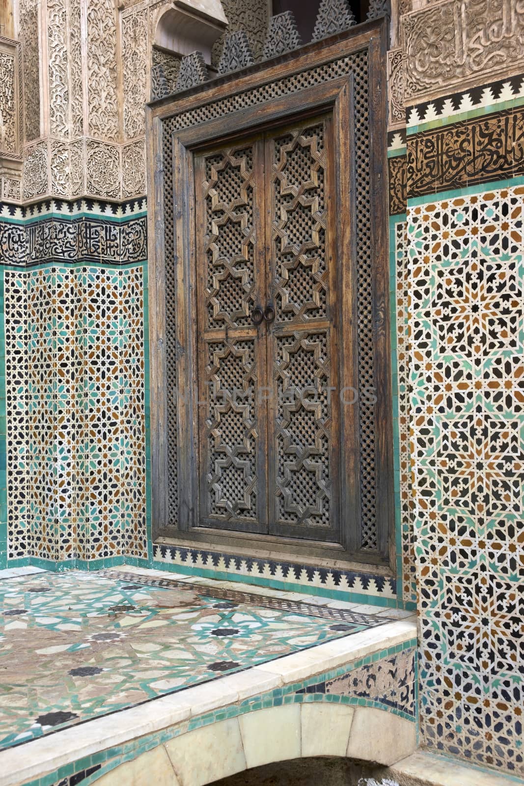 Ornate carving on the plastered walls and on the woodwork in the courtyard of the historic Madrasa Bou Inania in the ancient medina of Fes in Morocco