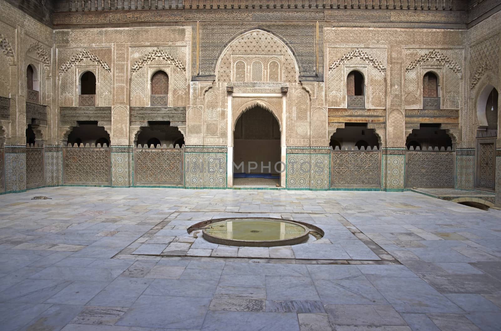 Ornate carving on the plastered walls and on the woodwork in the courtyard of the historic Madrasa Bou Inania in the ancient medina of Fes in Morocco