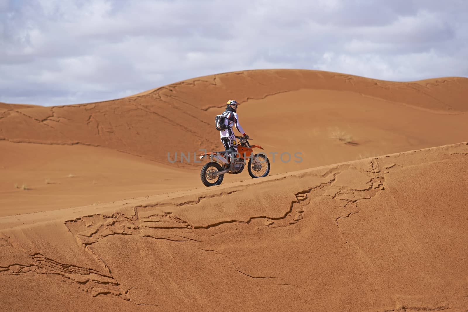 Person motorbiking across the sand dunes in the Sahara Desert of Morocco in North Africa