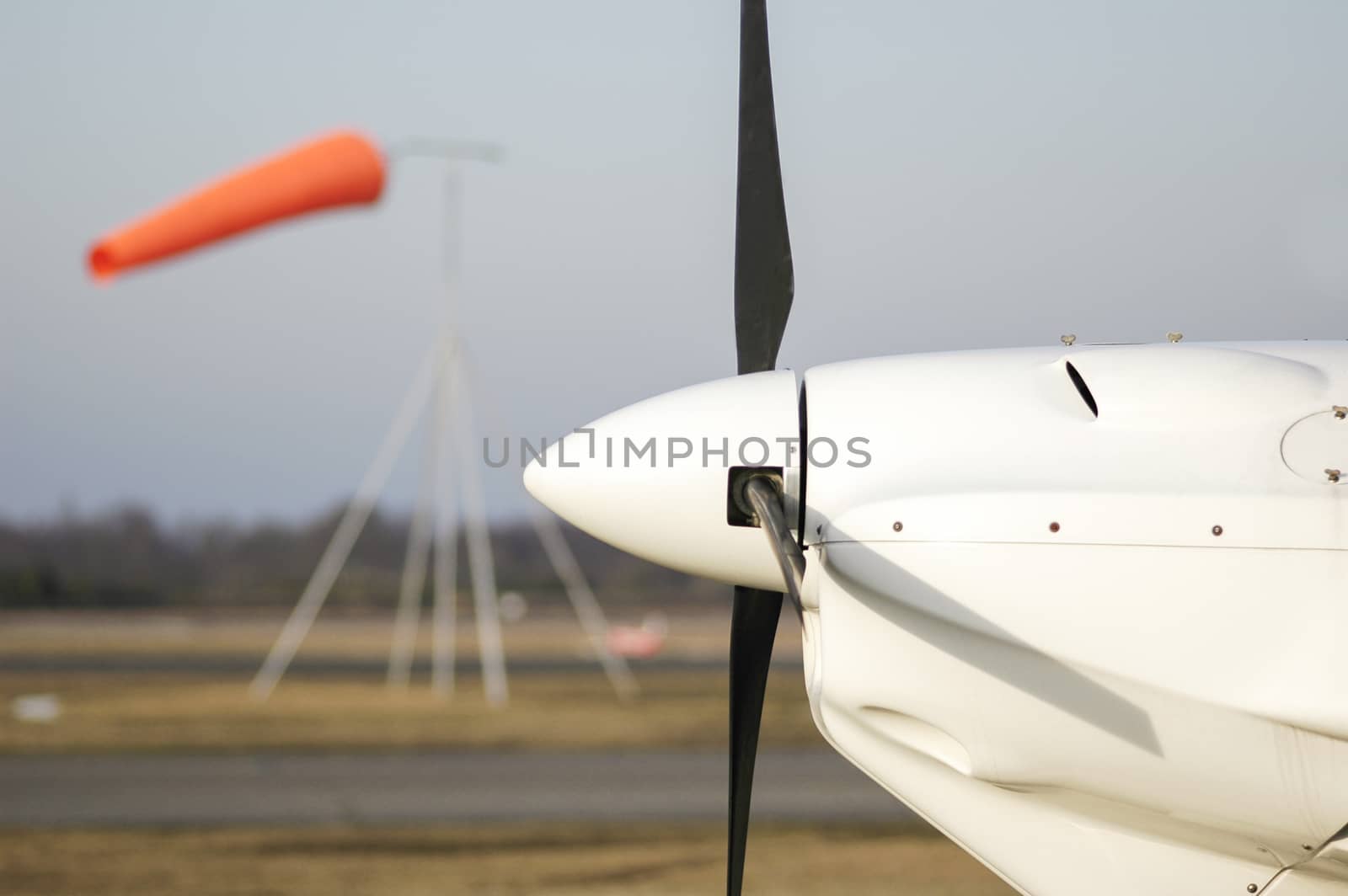 propeller aircraft with a windsock in the background