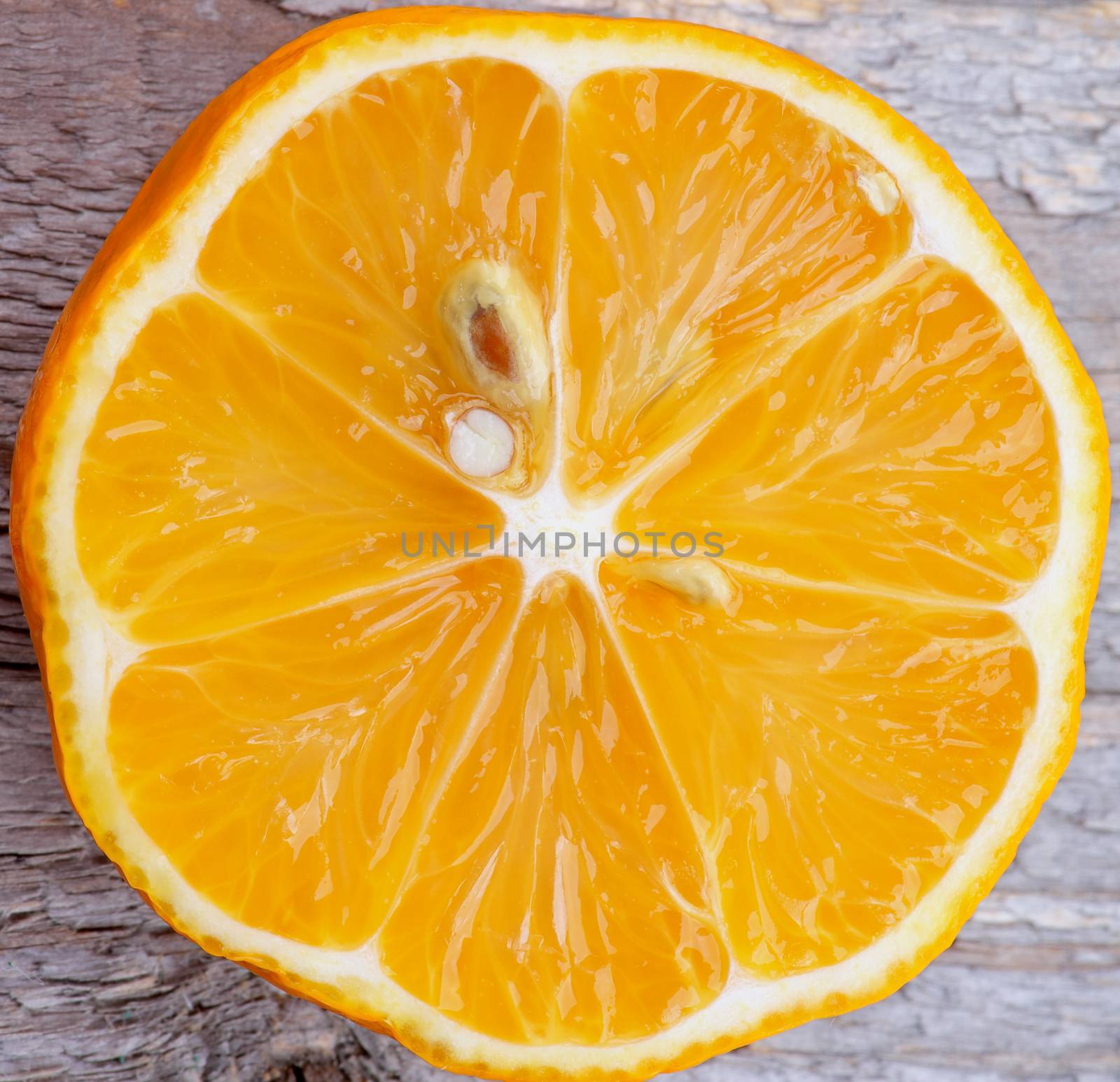 Slice of Fresh Ripe Tangerine Cross Section closeup on Wooden background