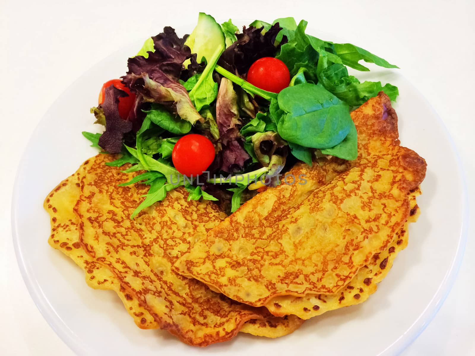 Pancakes and green salad, healthy and tasty food.