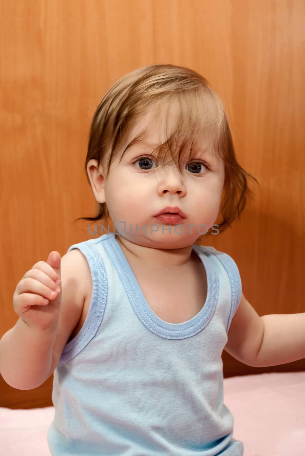 Portrait of a funny little boy in blue shirt.