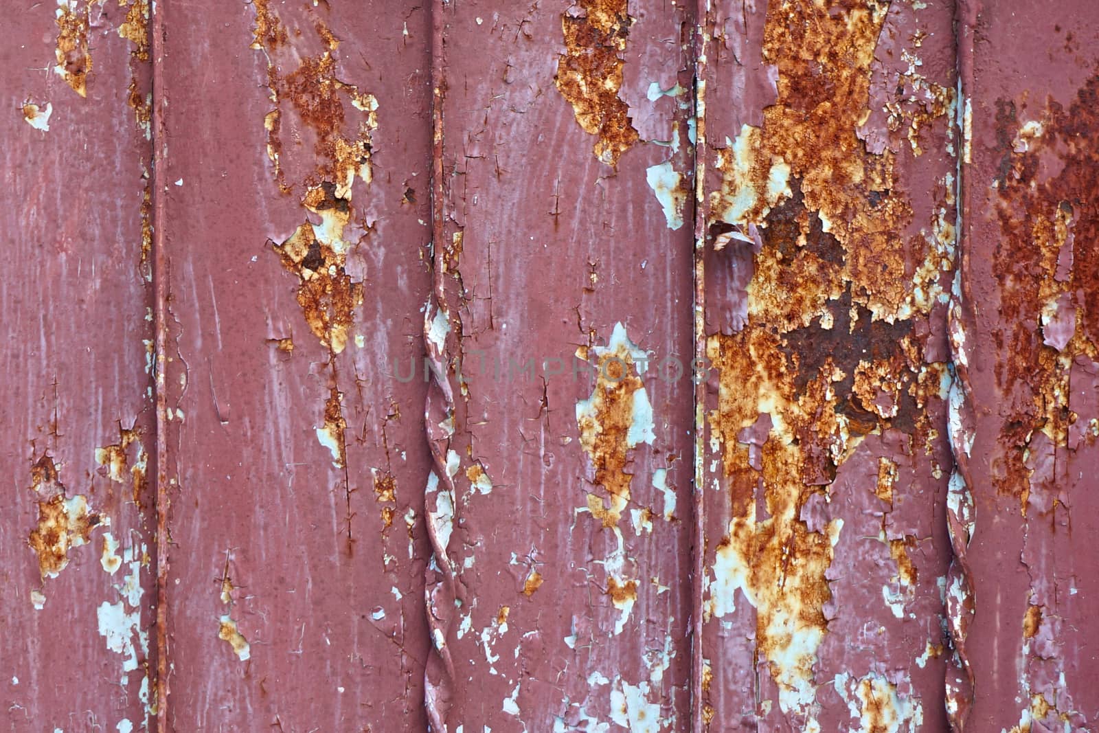 Old red iron door peeling paint and rust texture background.