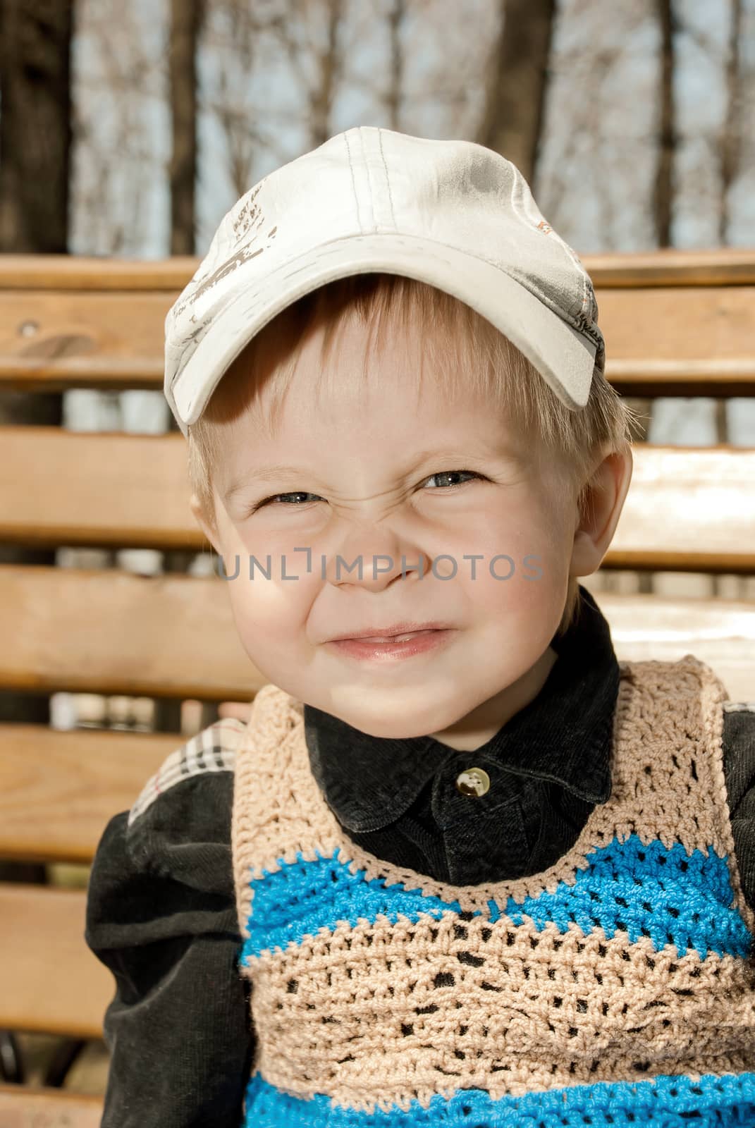 Portrait of little boy in cap outdoors.