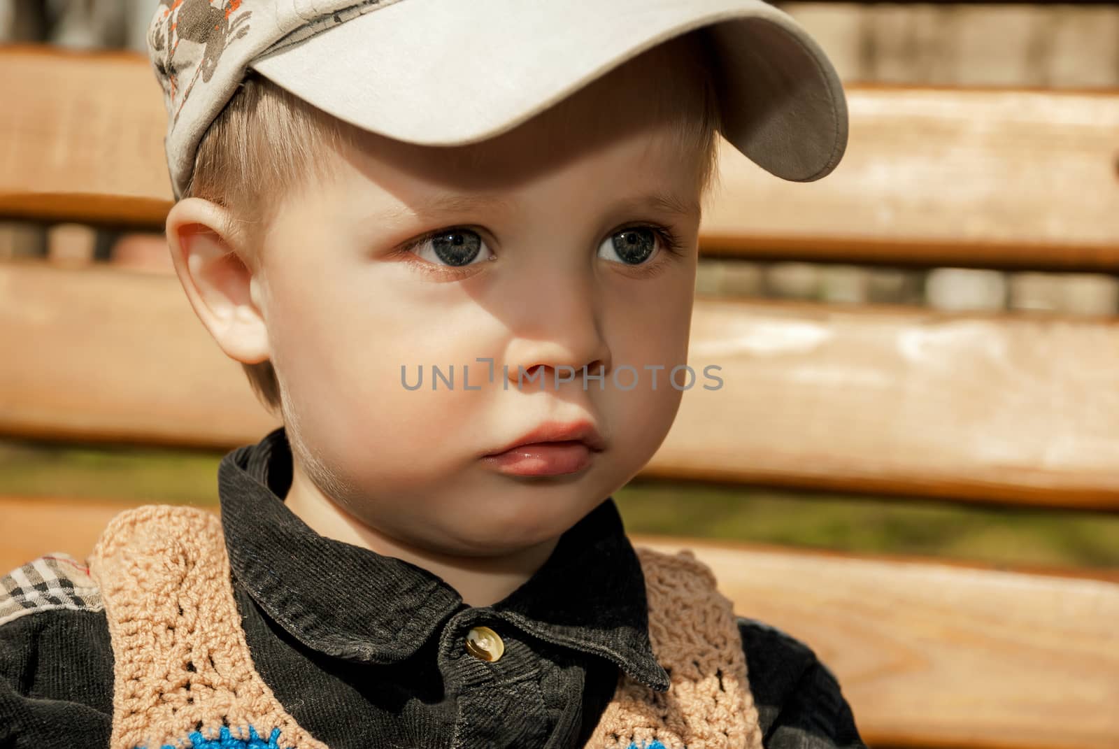 Portrait of little boy in cap outdoors.