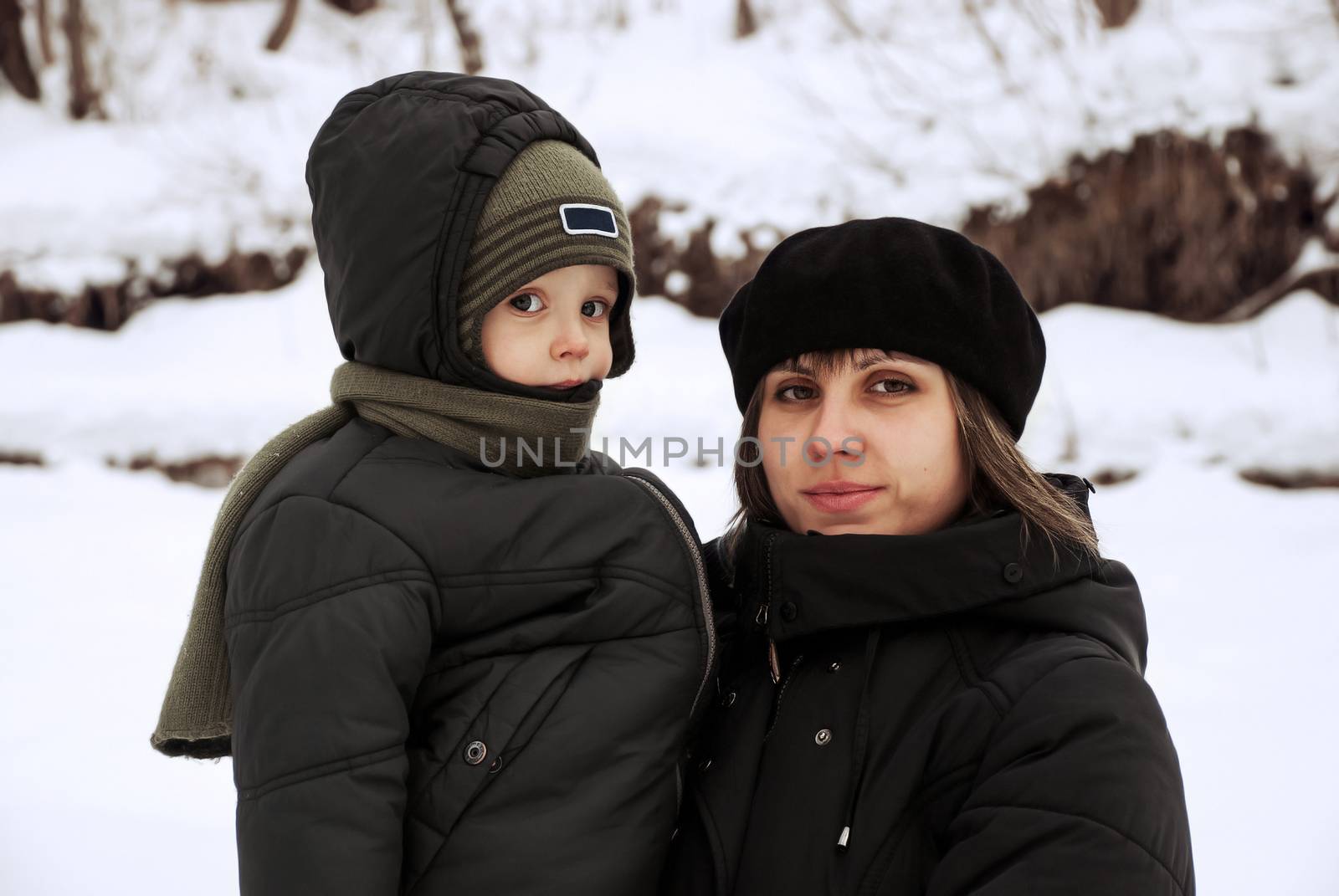 Mother with baby in the winter outdoors.