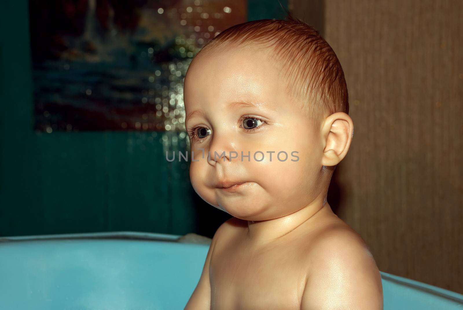 Baby face close-up bathing in the tub.