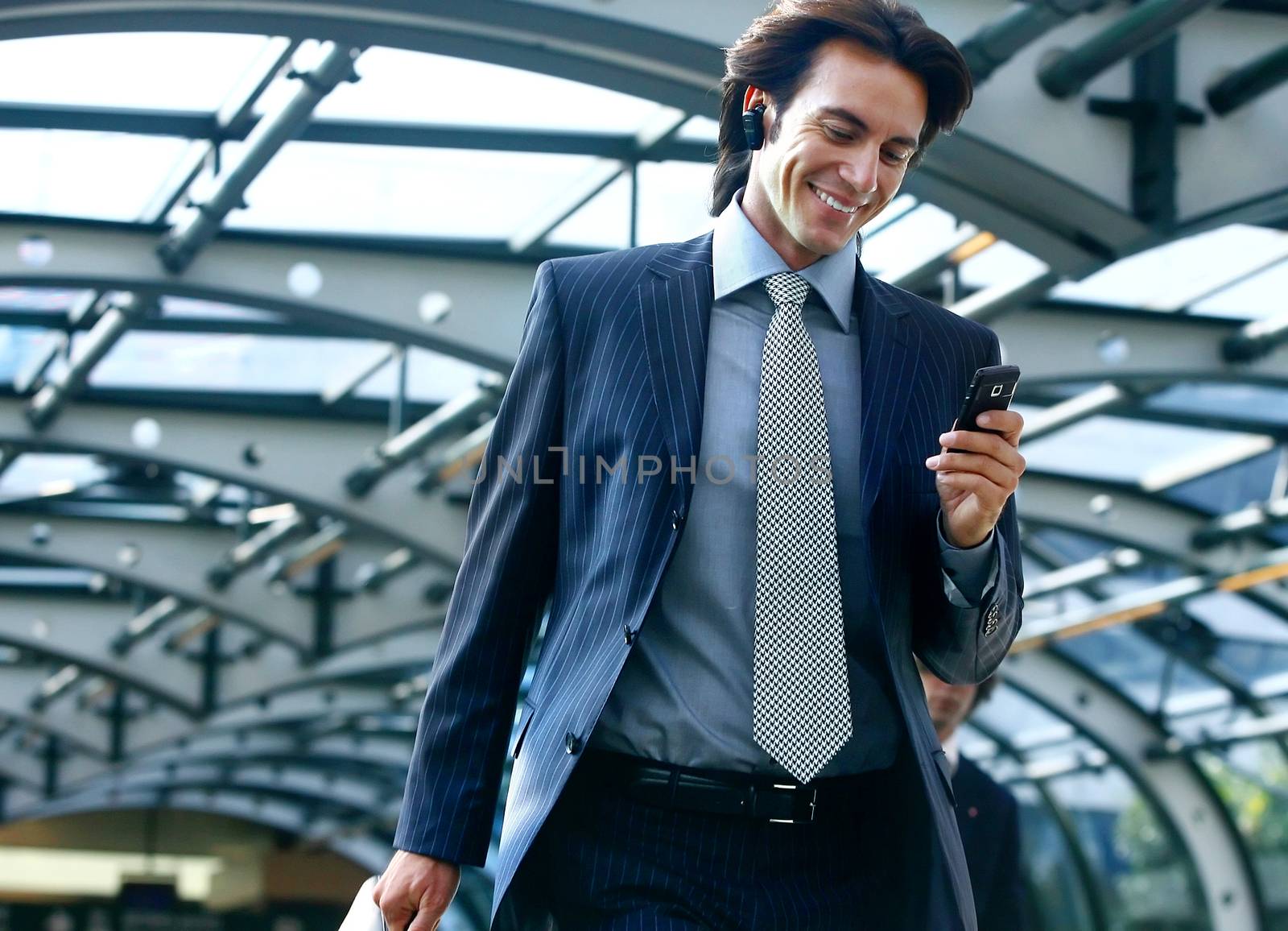 happy businessman talking on mobile phone in airport