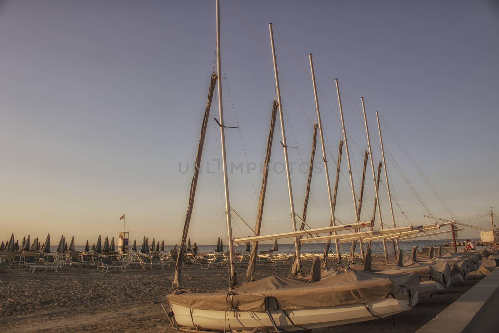 bathhouse and sailing boats on the seaside near the harbour channel of Cervia in Northern Italy on the Adriatic Sea