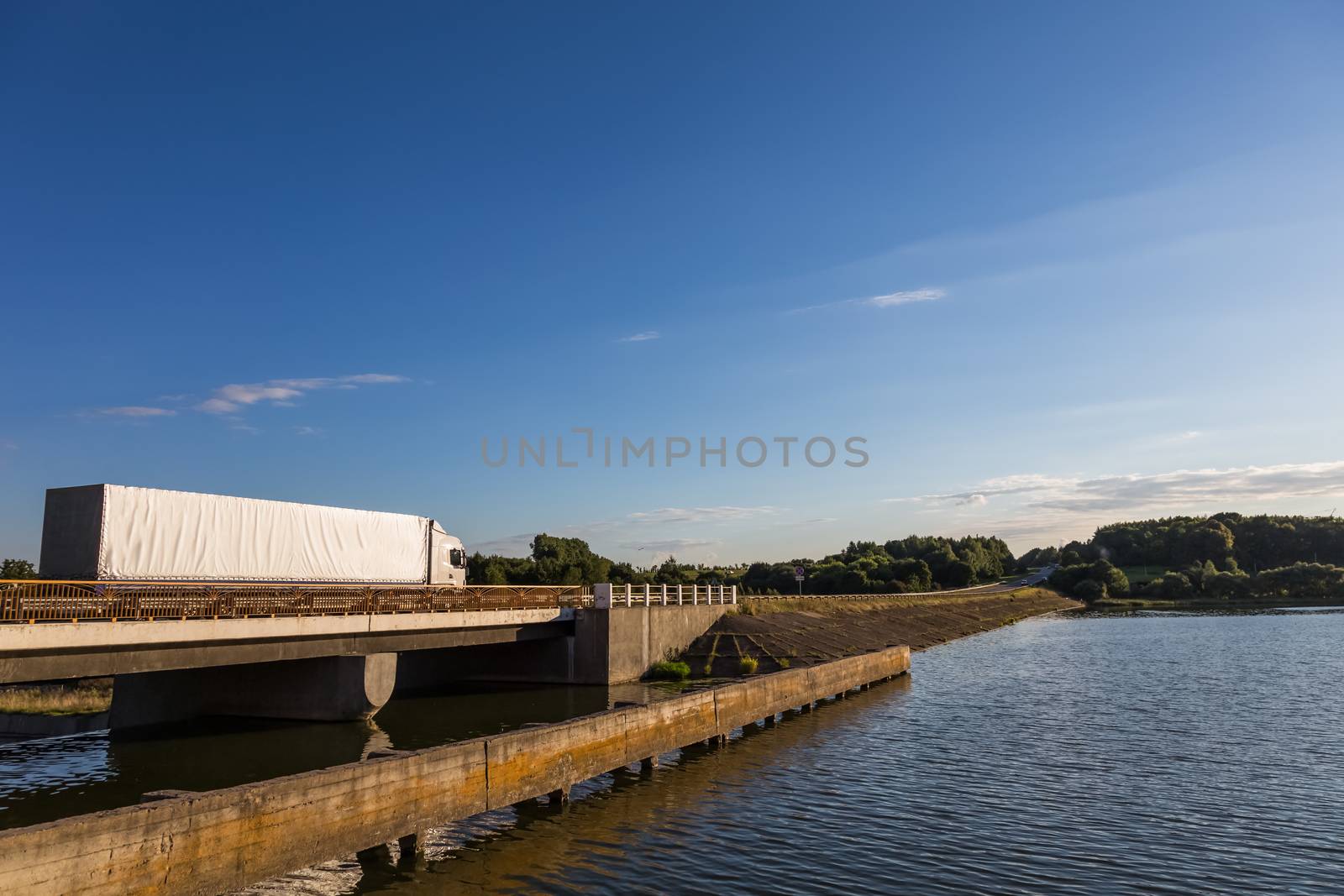 Truck delivery cargoes. Moving through lake on the bridge