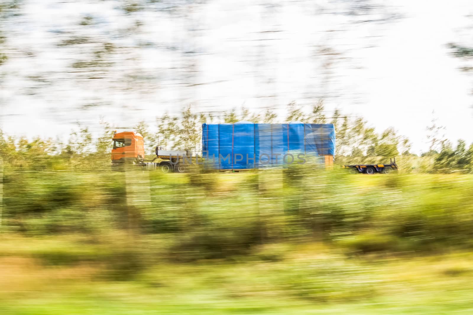 Truck delivery oversized cargo behind the trees