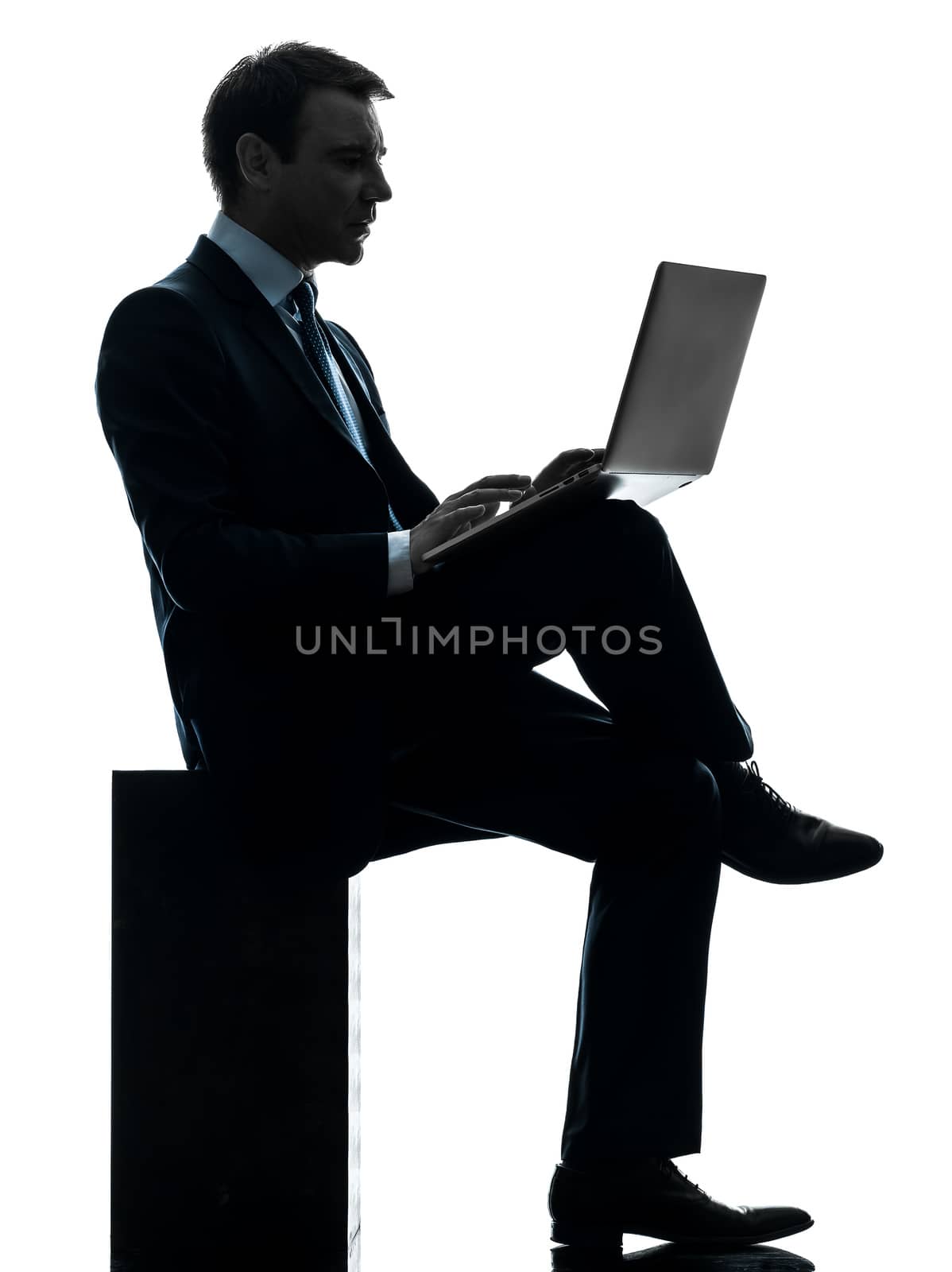 one caucasian businessman computing laptop computer in silhouette studio isolated on white background