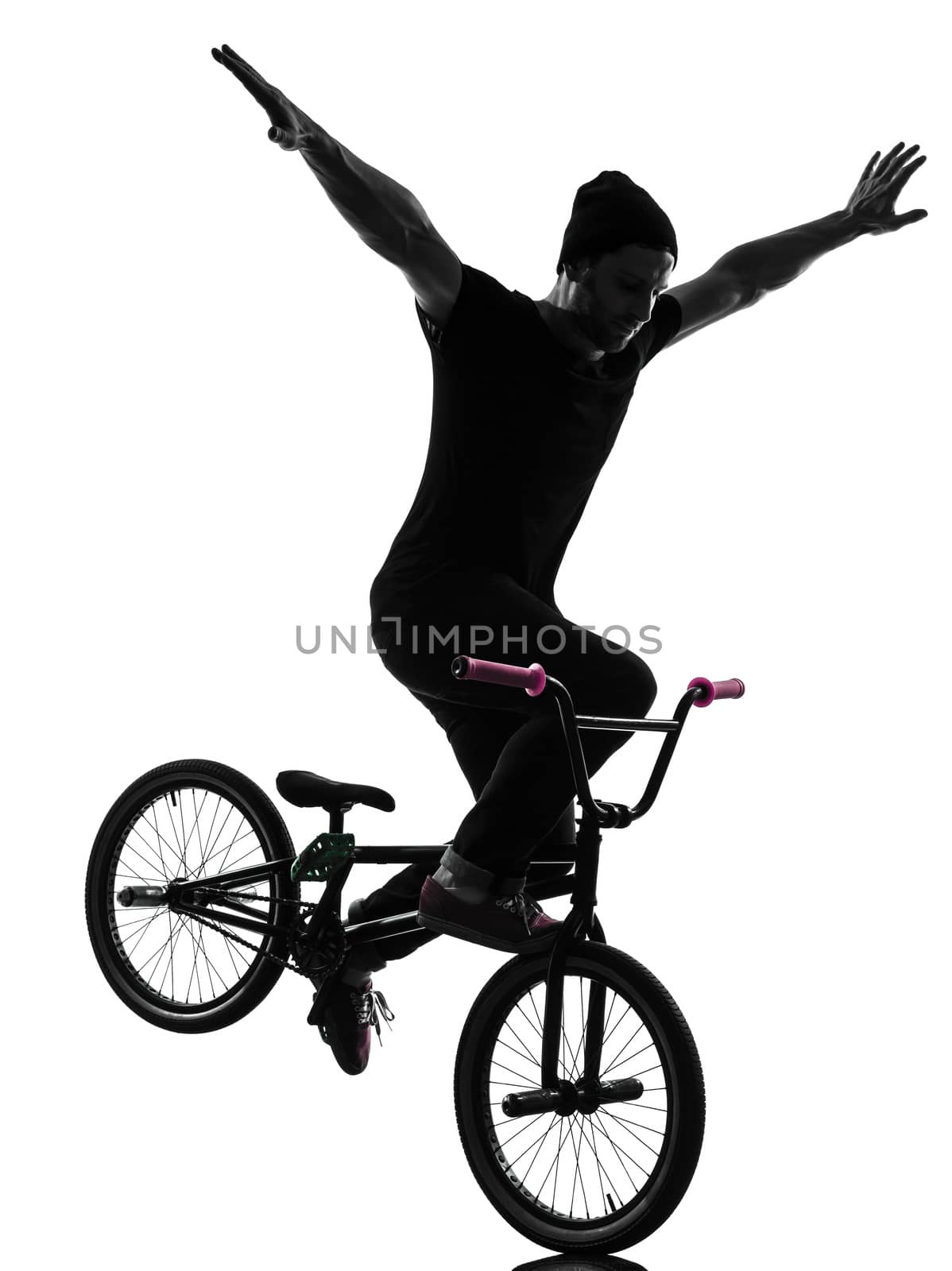 one caucasian man exercising bmx acrobatic figure in silhouette studio isolated on white background