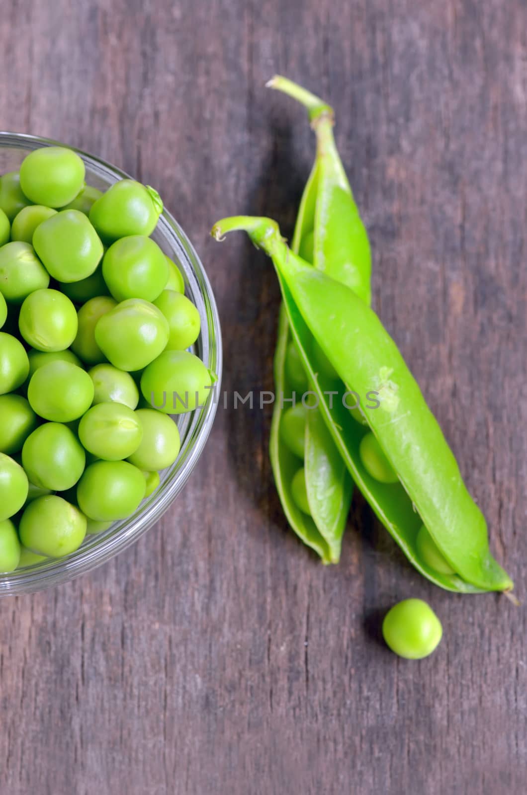 Fresh green pea pod on old wooden background