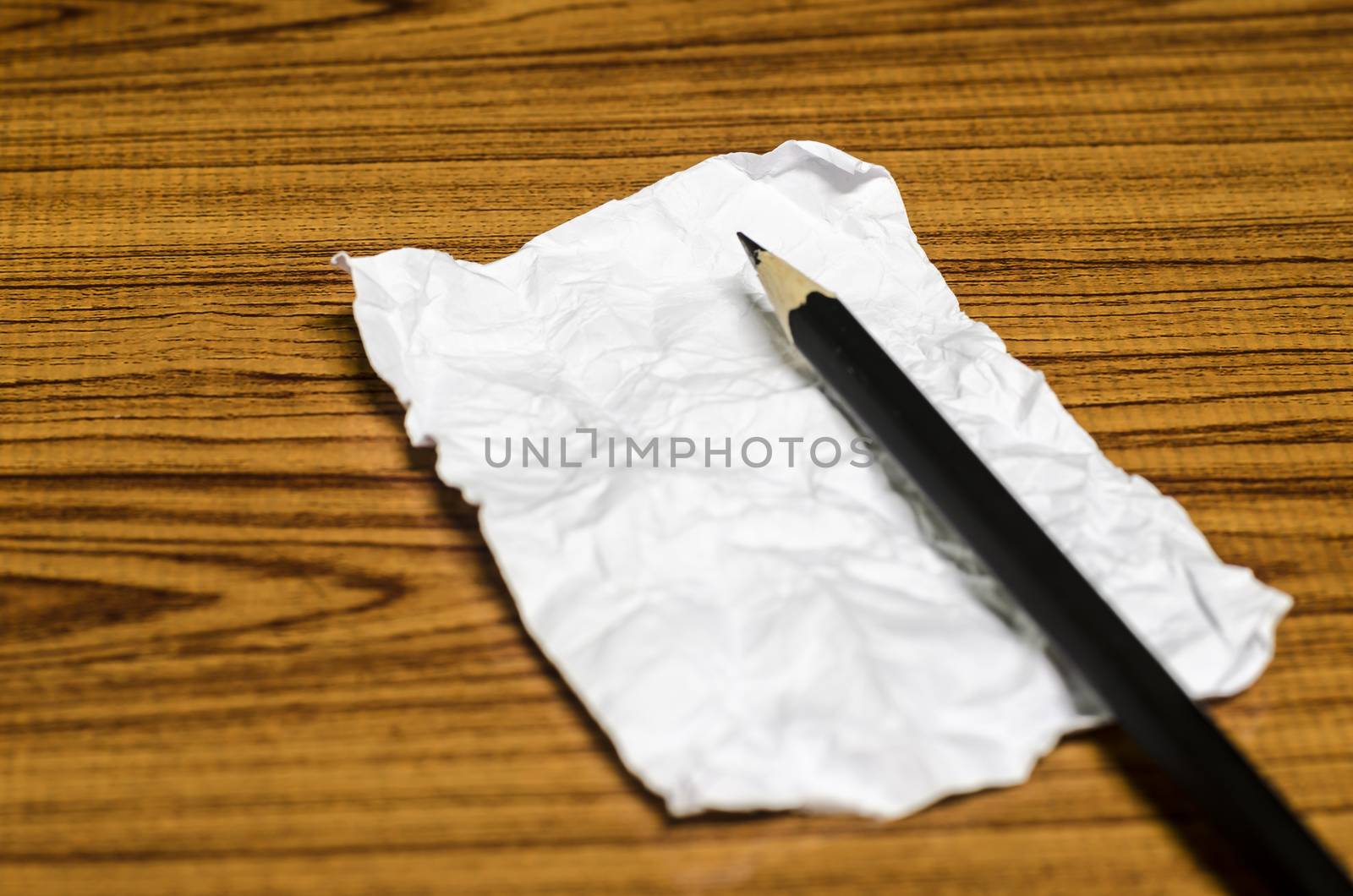 paper scrap with pencil on wood background
